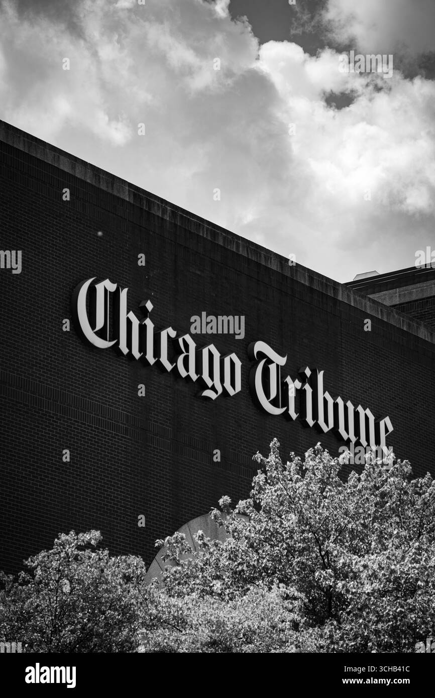 L'edificio del Chicago Tribune firma in grassetto su un muro di mattoni, catturato in bianco e nero sotto il cielo nuvoloso. Foto Stock