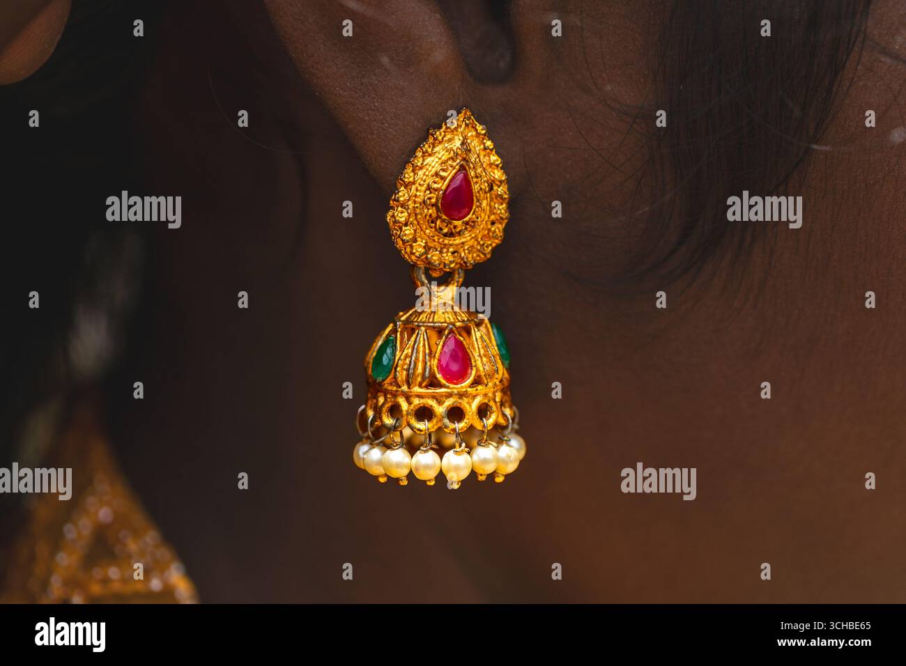 Primo piano dei tradizionali orecchini in oro indossati a Coimbatore India Foto Stock