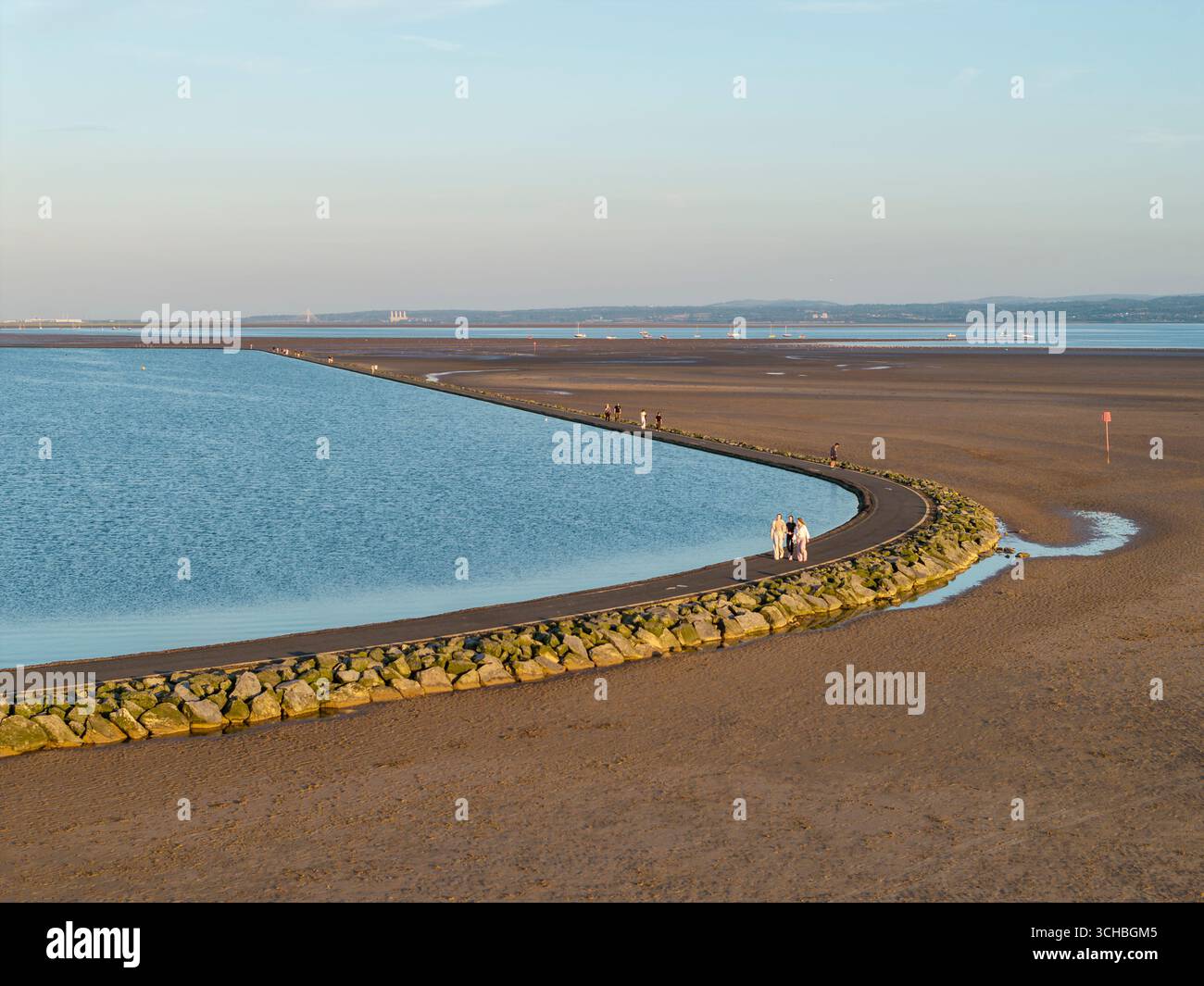 WIRRAL, MERSEYSIDE, INGHILTERRA - 09 LUGLIO 2025: Le persone camminano intorno al lago marino West Kirby, Wirral Foto Stock