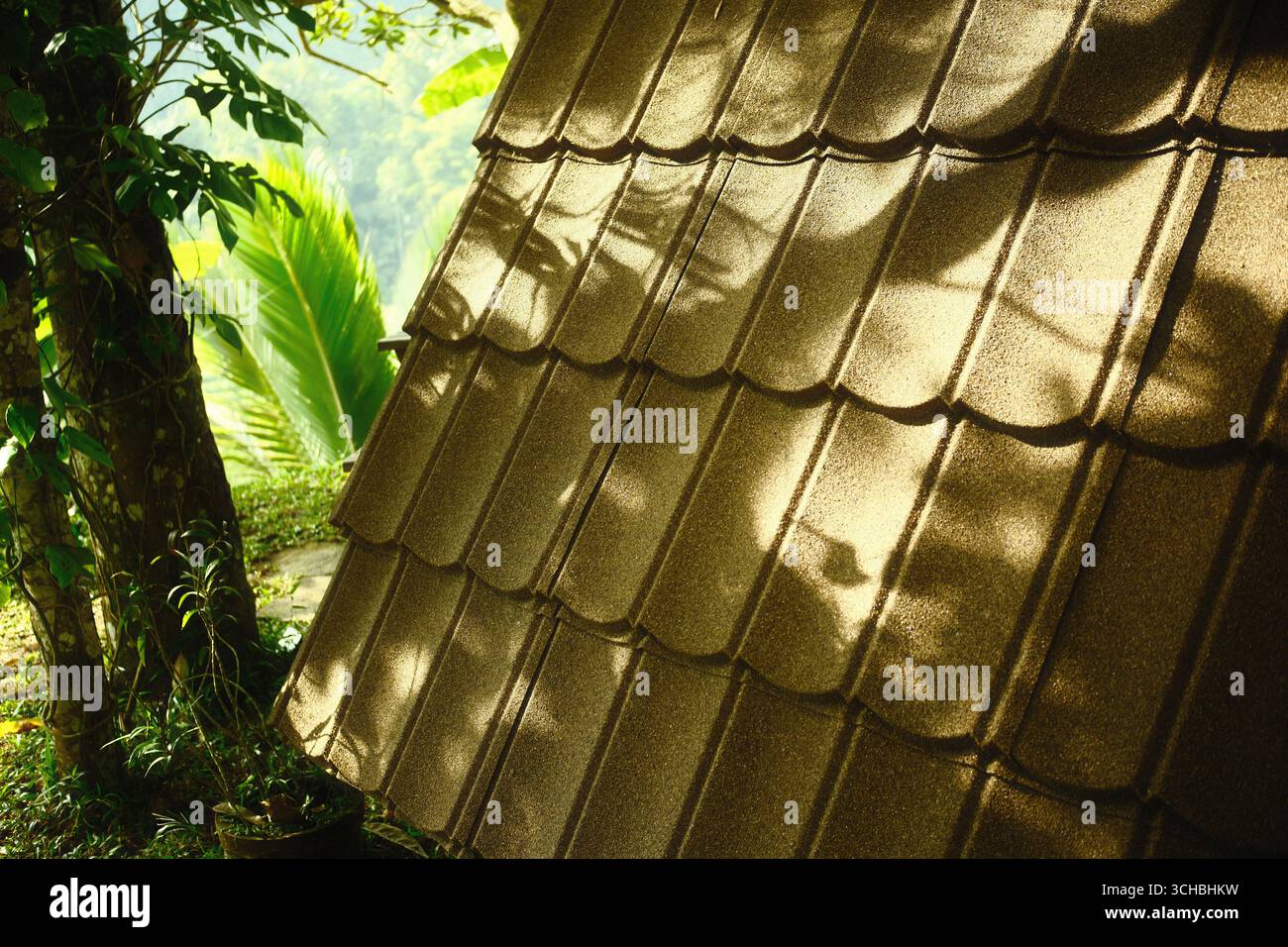 Luce solare e ombra su Un tetto in metallo marrone con un motivo a piastrelle testurizzate Foto Stock