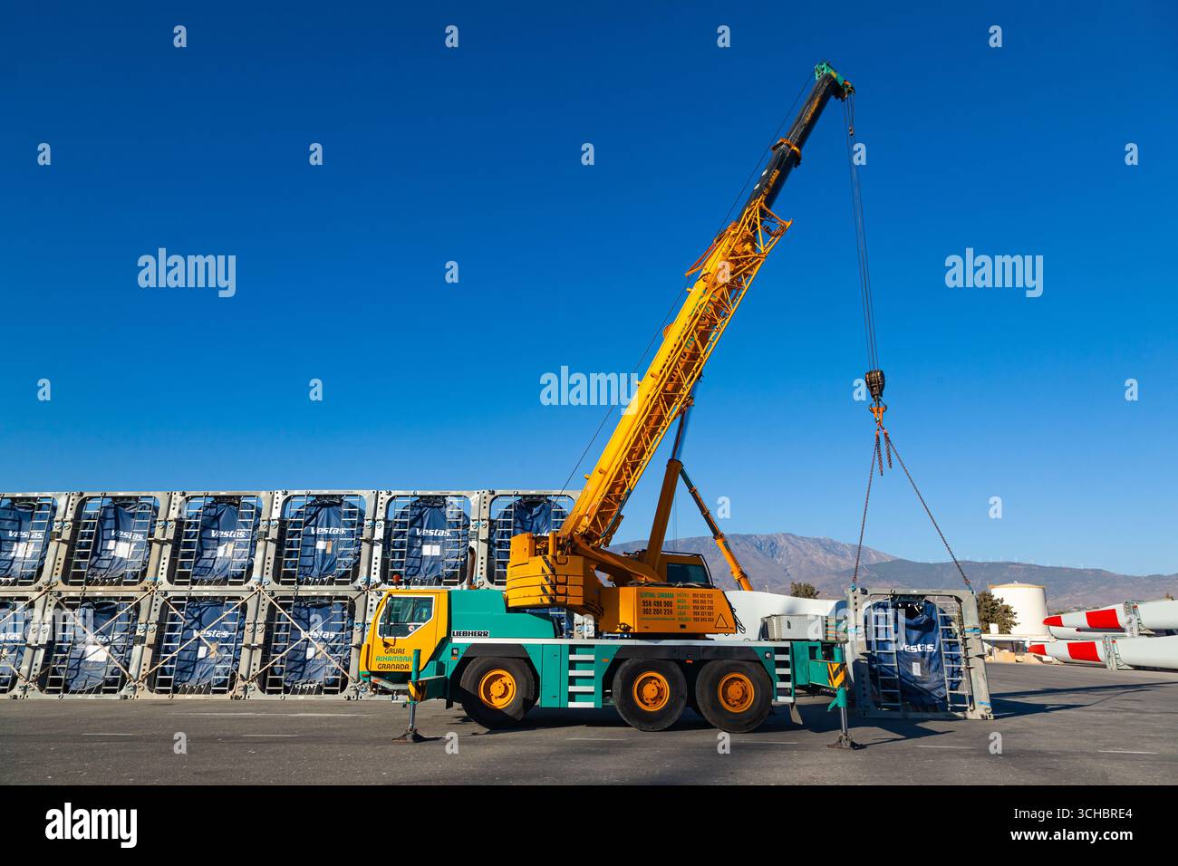Motril, Spagna - 09.27.2022: Trasporto di pale per turbine eoliche Vestas nel porto marittimo di Motril in Spagna con gru per camion Liebherr. Foto Stock