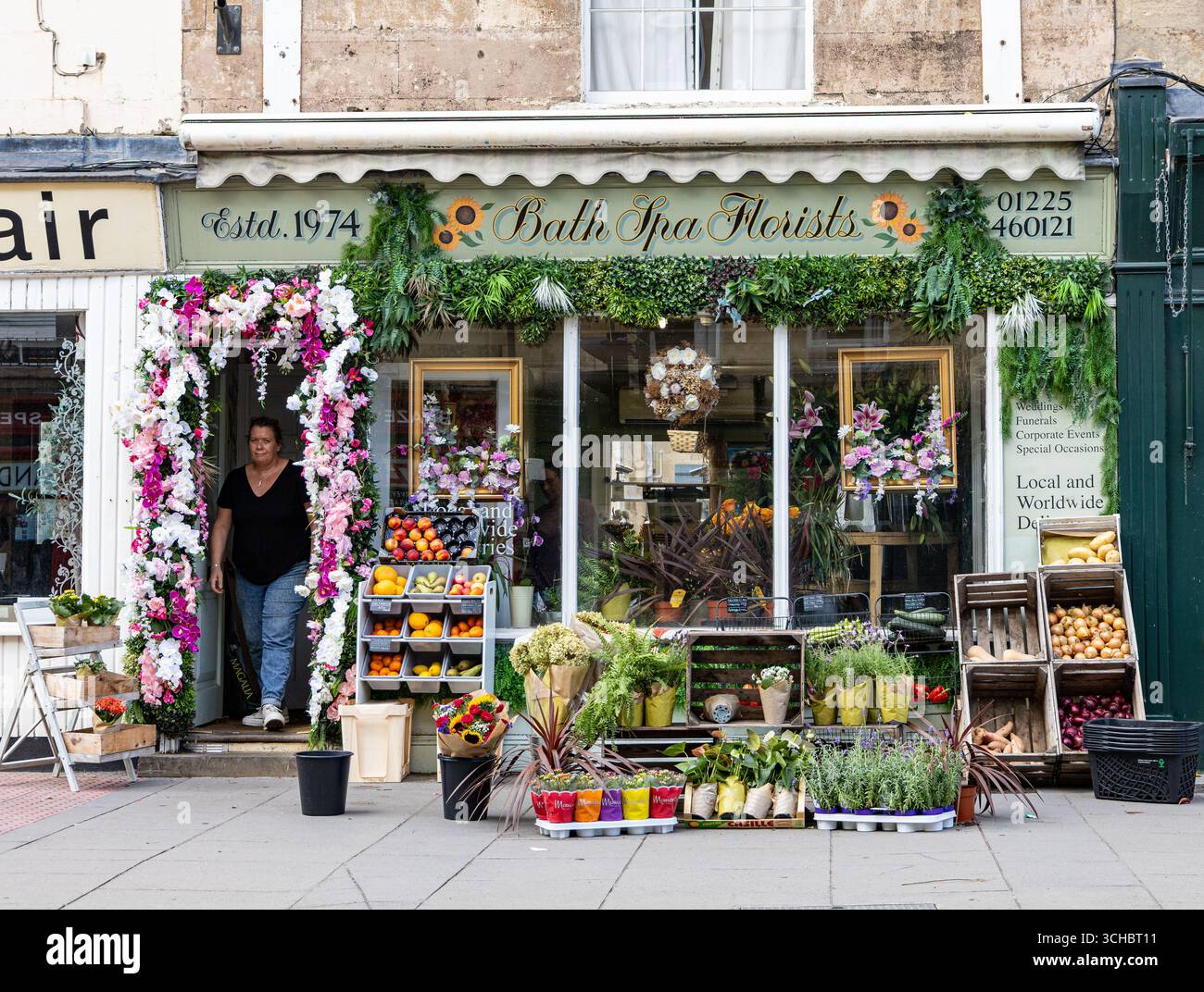 Vista sulla strada di un affascinante negozio di fiori, fioristi della Bath Spa con colorate esposizioni floreali, piante in vaso e un'accogliente entrata adornata di verde Foto Stock