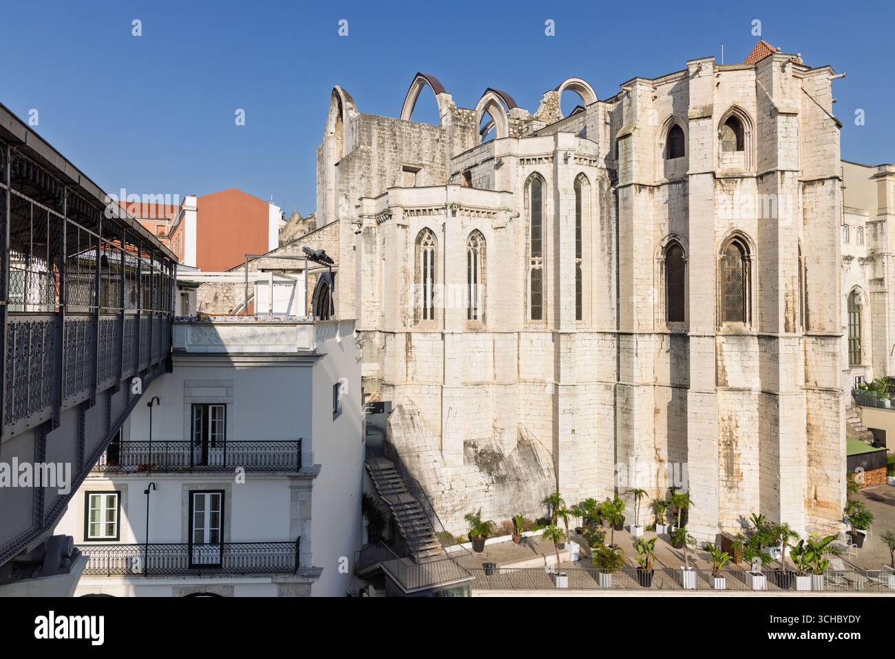 I resti scheletrici della chiesa del Carmo in stile gotico sono alti contro un cielo azzurro. Le rovine, danneggiate dal terremoto del 1755, sono un toccante h Foto Stock