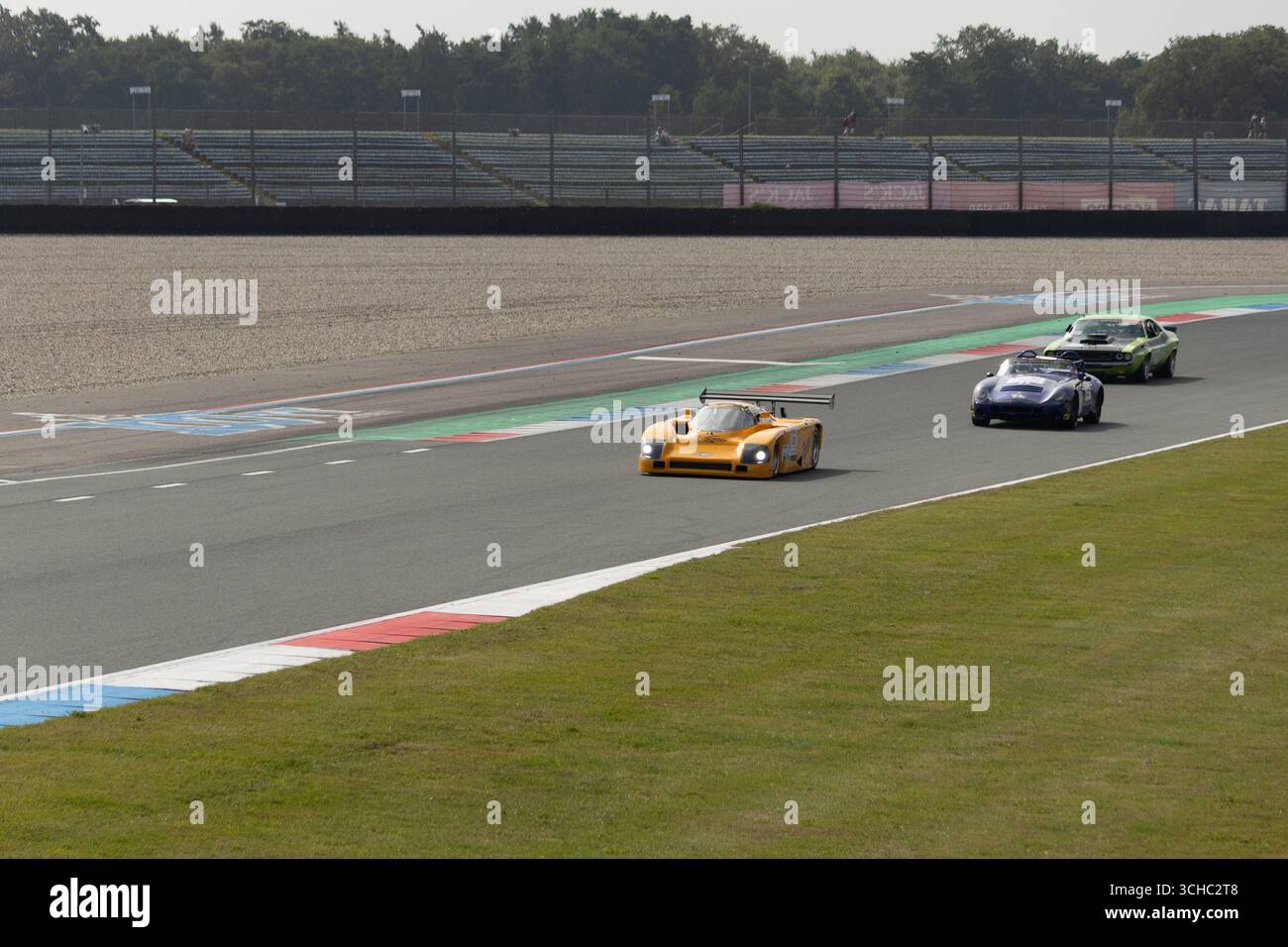 Tre vetture corrono intorno al circuito TT di Assen durante un weekend di gara Foto Stock