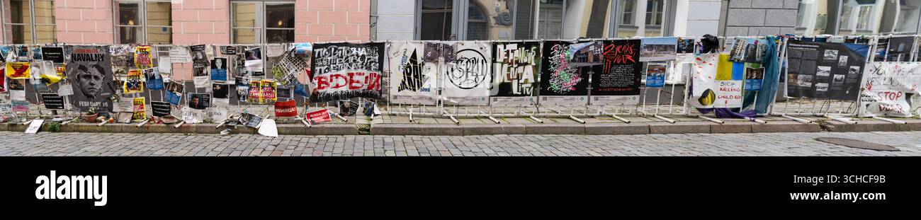 Esposizione Panorama di Street art con manifesti di protesta e graffiti in strada acciottolata nel centro storico della città europea Foto Stock