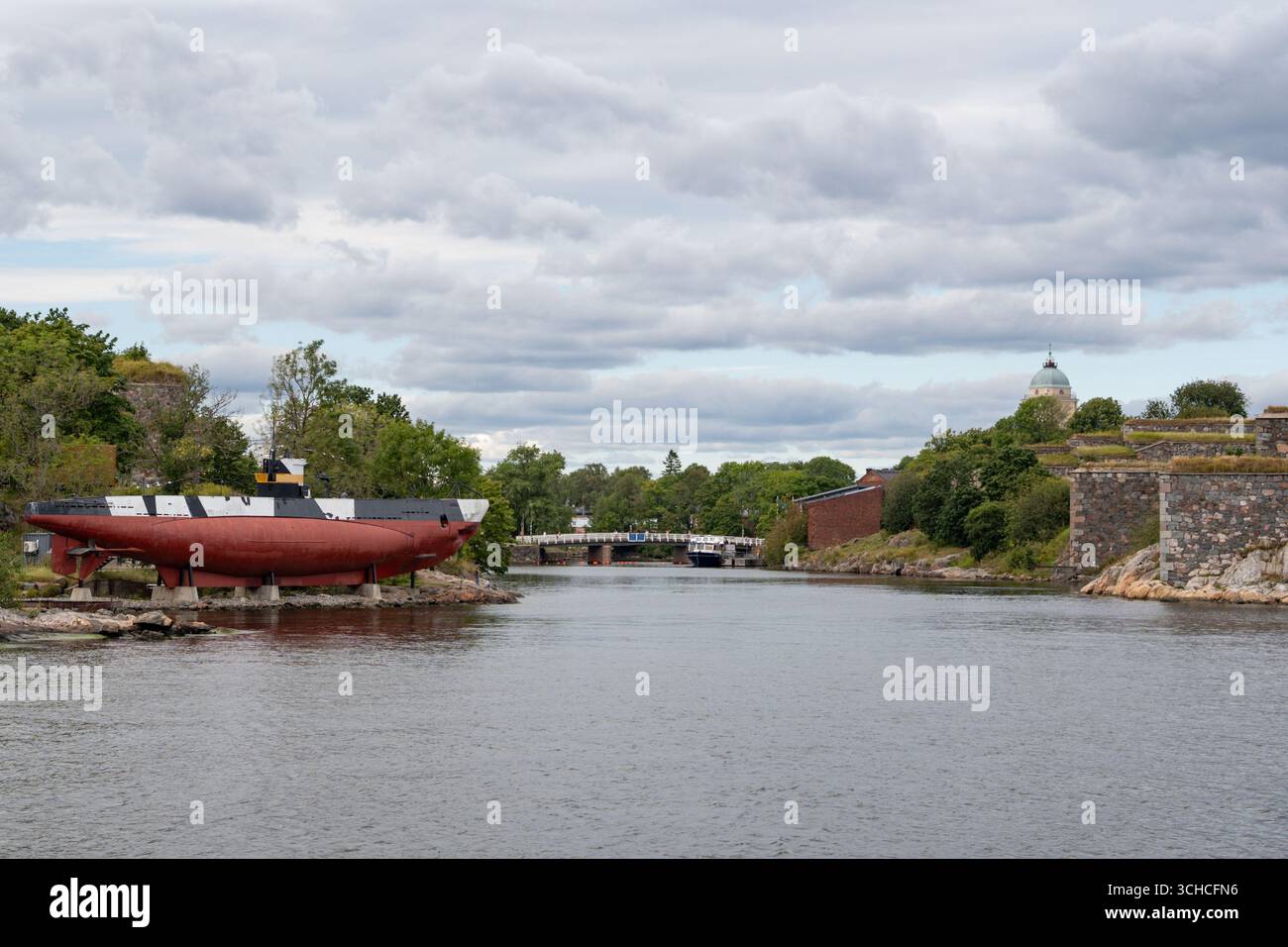Porto storico con sottomarini e mura della fortezza sotto il cielo nuvoloso a Helsinki in Finlandia Foto Stock
