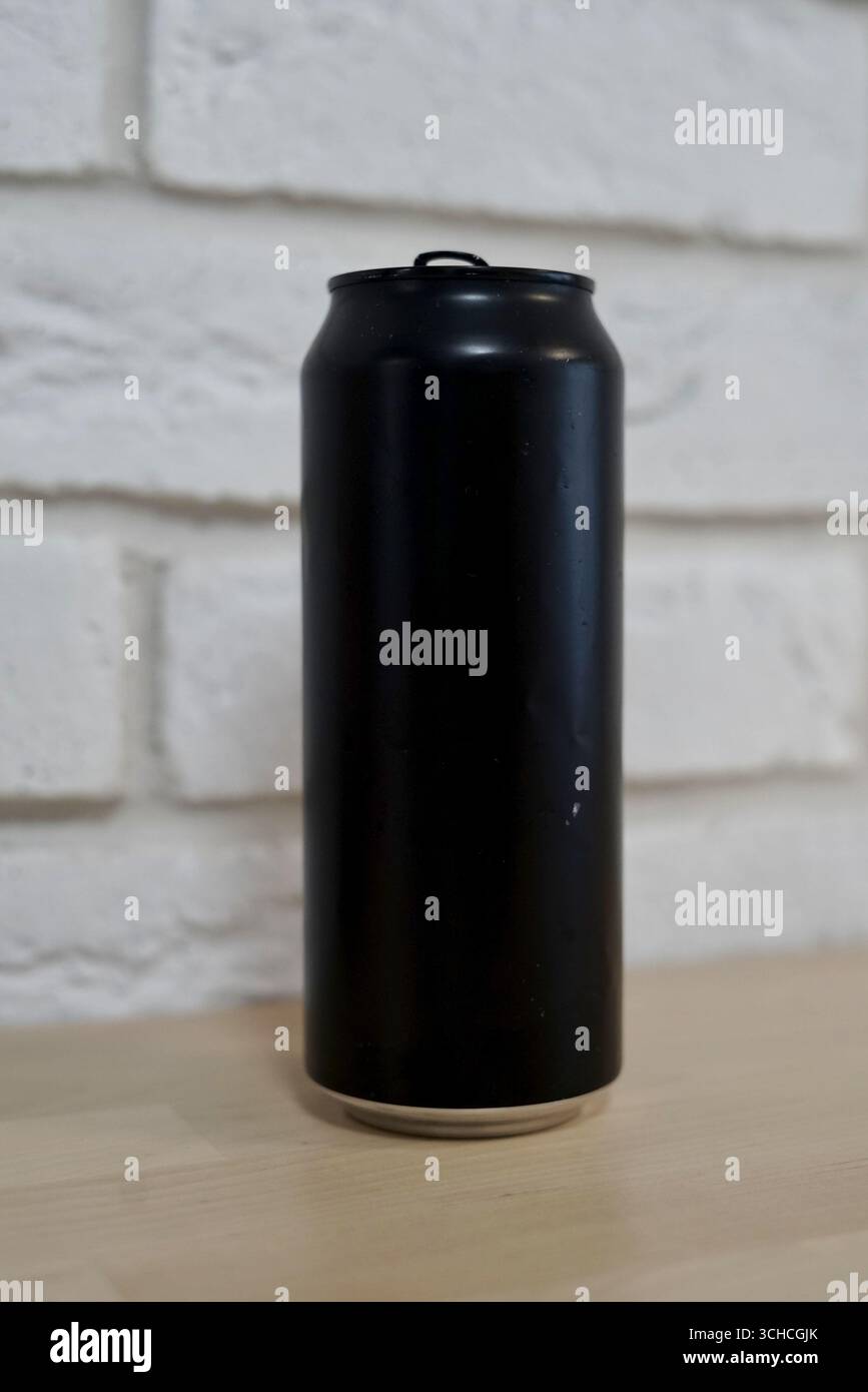 Una vernice spray nera può poggiare su una superficie murale in mattoni bianchi Foto Stock
