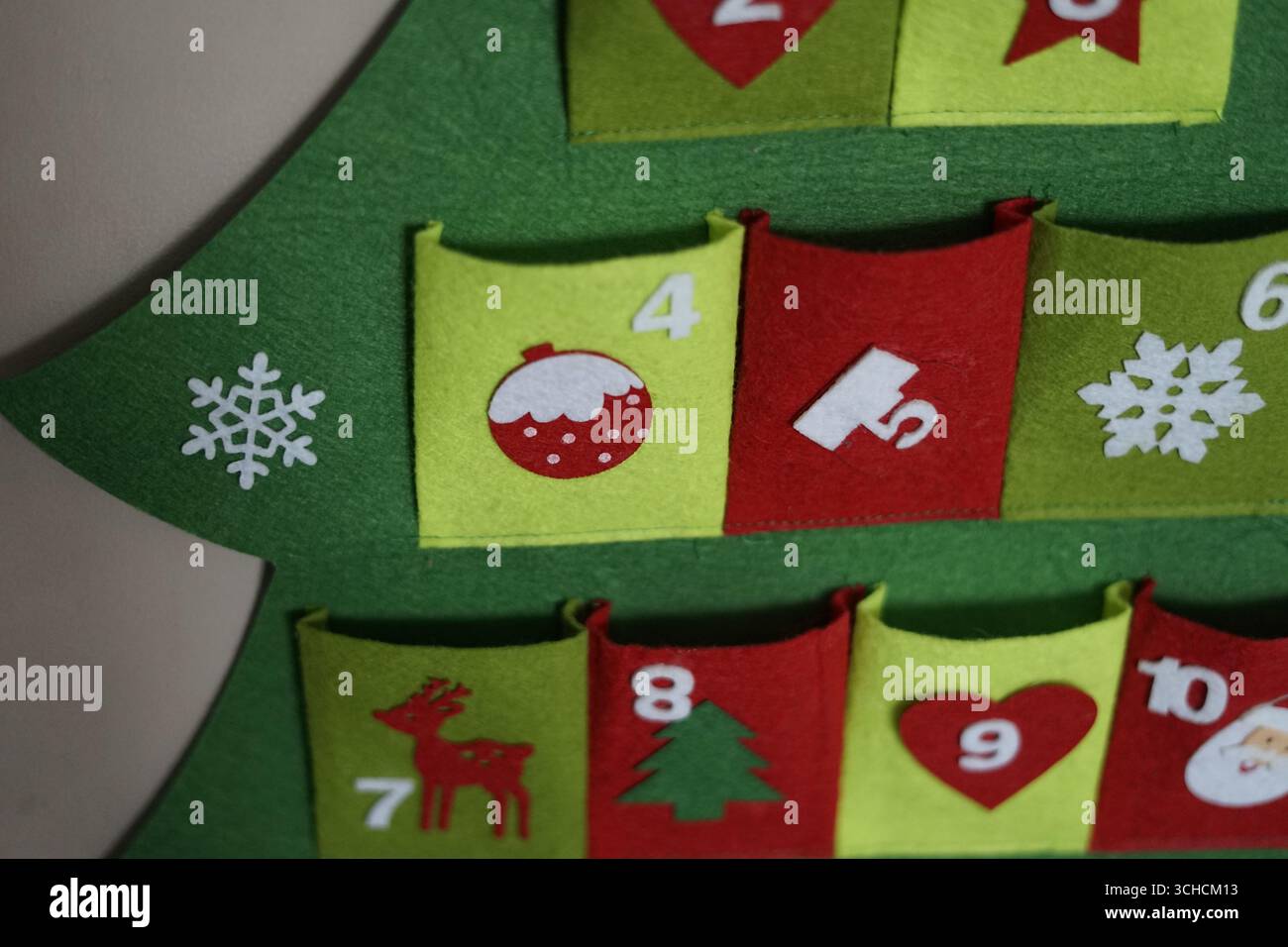 Calendario dell'avvento natalizio a forma di albero di Natale, adornato da colorate tasche in feltro e ornamenti a tema natalizio, perfetto per il conto alla rovescia verso Cristo Foto Stock