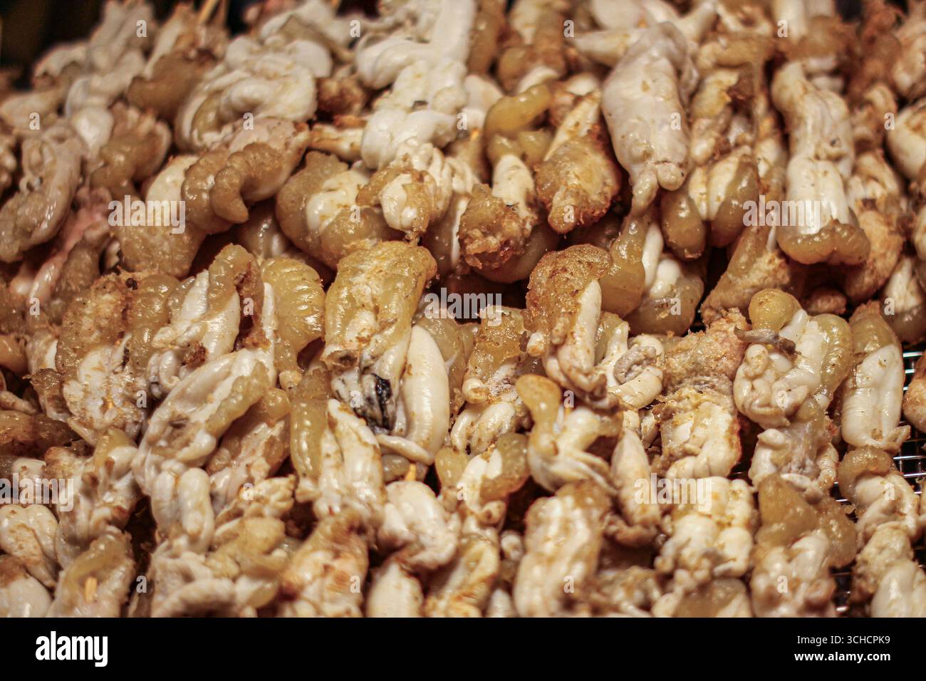 Uova di calamari grigliate affumicate dorate, piatti di pesce tradizionale tailandese impilati sul vassoio Popolare nei mercati notturni e nel turismo culinario. Foto Stock