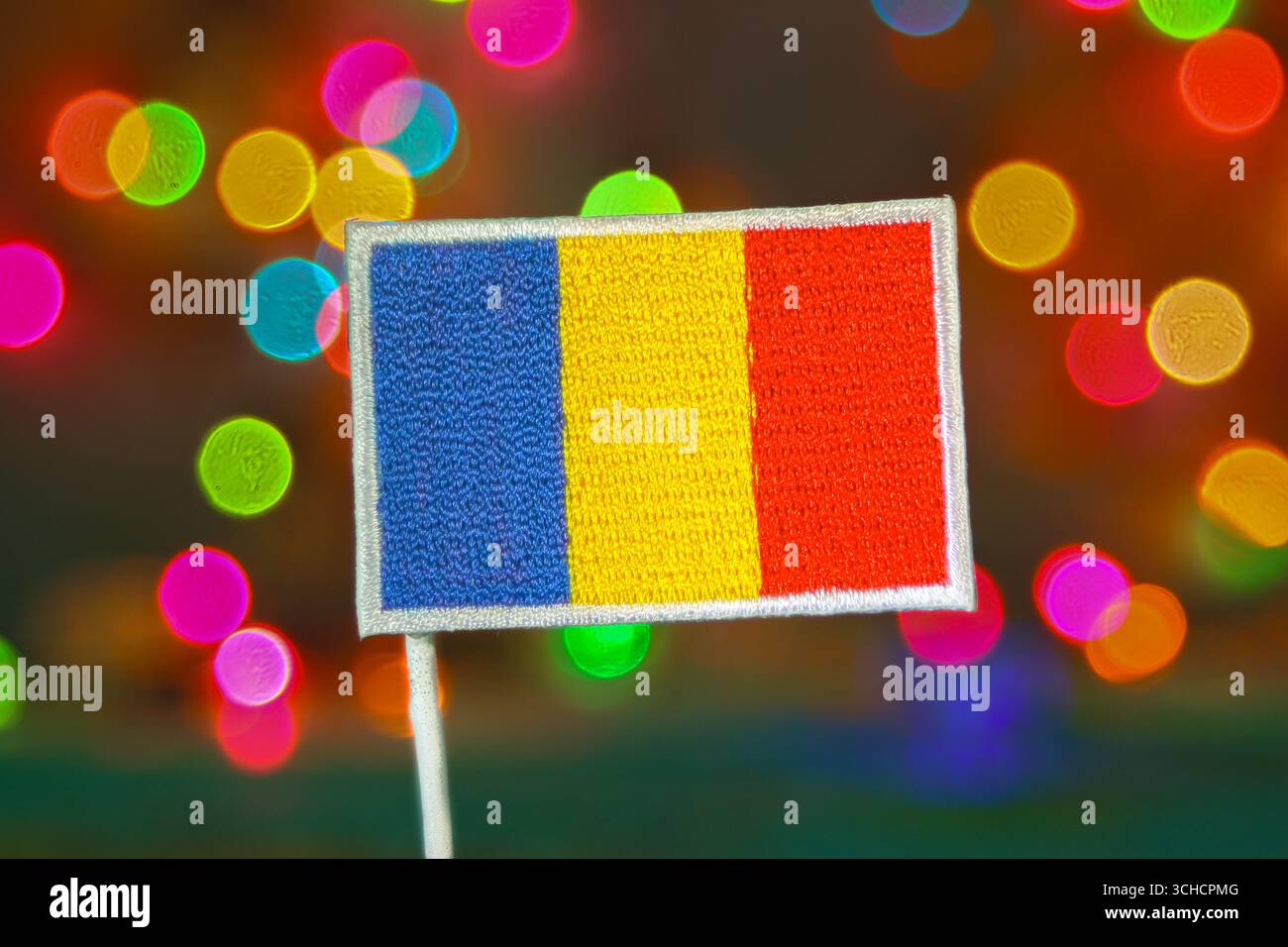 Ricamo bandiera rumena con fuochi d'artificio bokeh arcobaleno, simbolo della celebrazione, Natale, Capodanno e orgoglio nazionale. Foto Stock