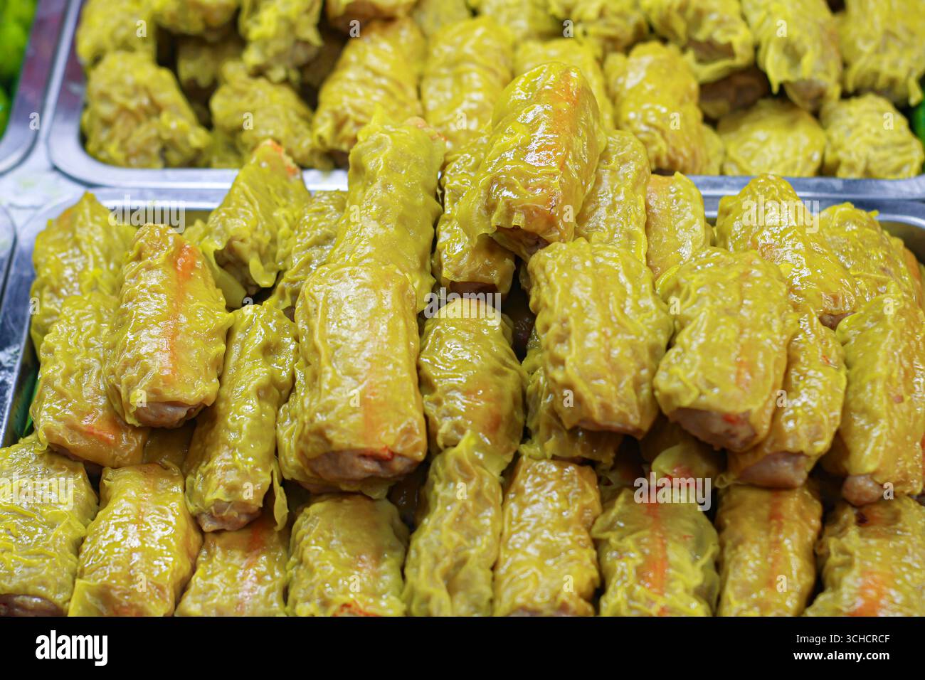 Gnocchi thailandesi gialli con ripieno di bastoni di granchio disposti sul vassoio, tradizionale cibo di strada asiatico che simboleggia il sapore autentico e la cena informale. Foto Stock