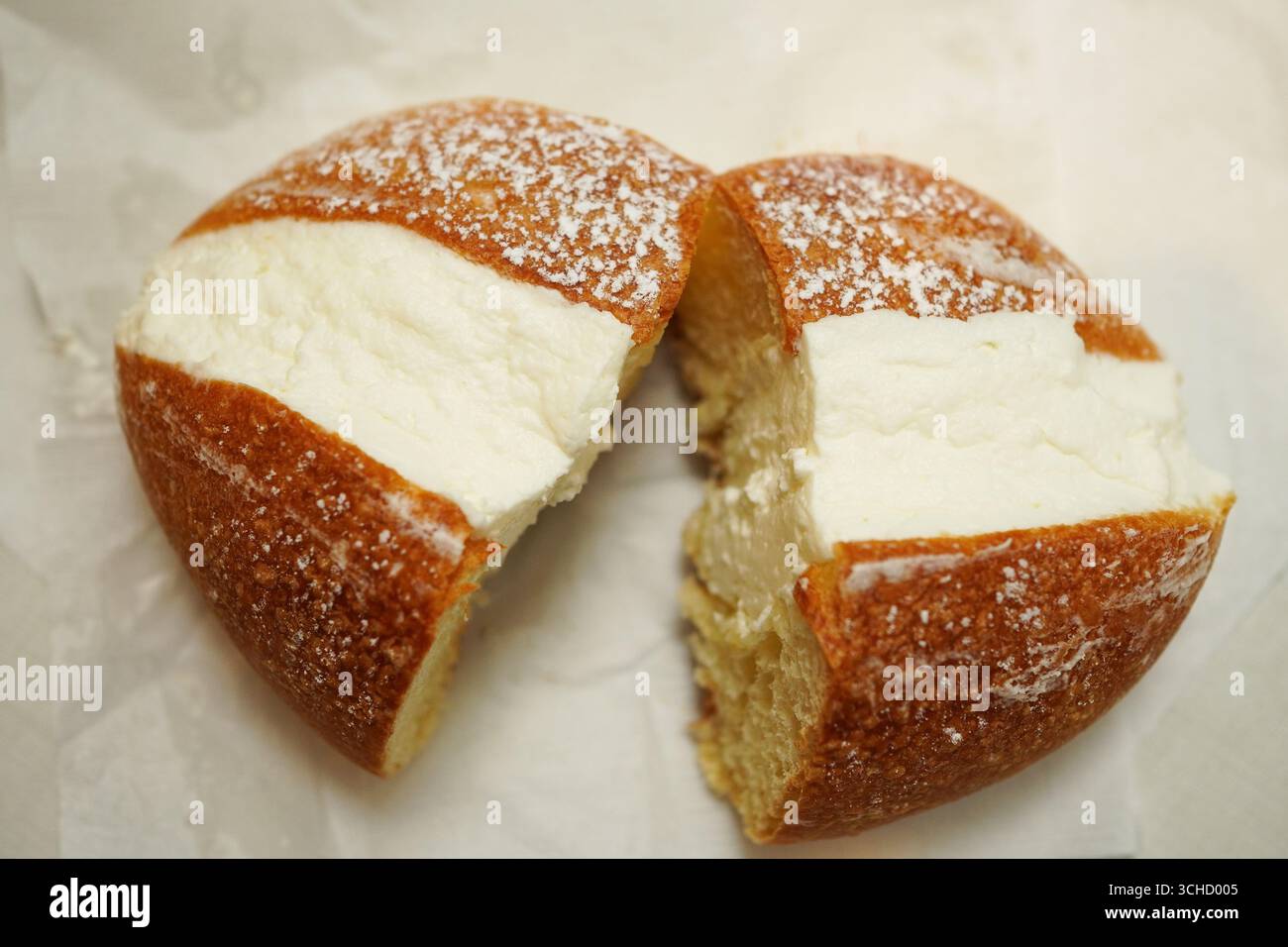 Maritozzo, un pane dolce italiano ripieno di panna montata tagliata a metà, visto direttamente dall'alto Foto Stock