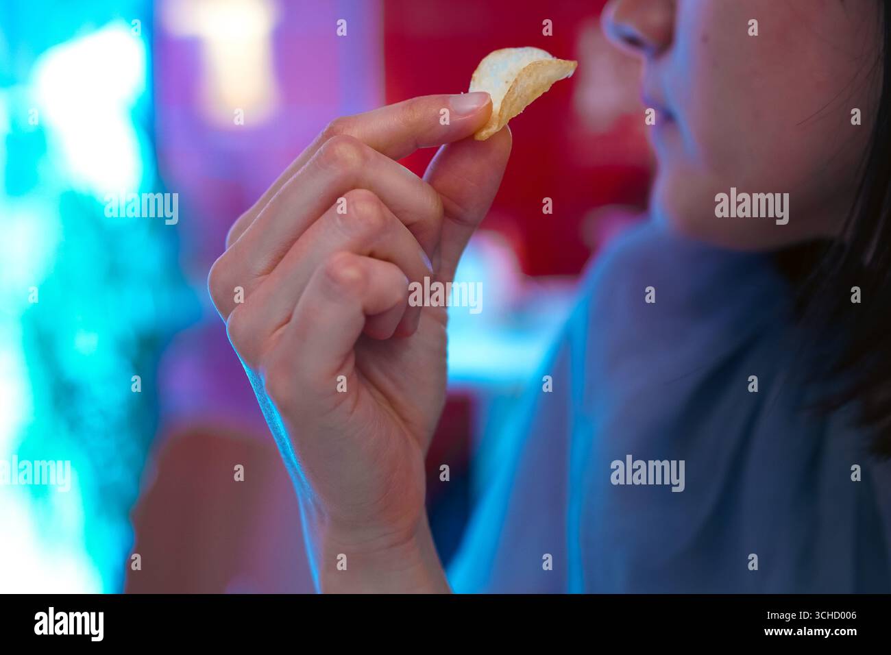 Una giovane donna che raccoglie patatine fritte servite come spuntino in un bar Foto Stock