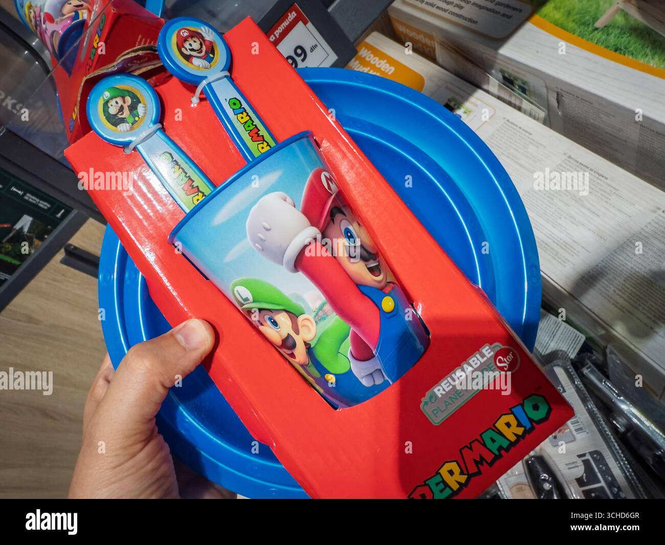 BELGRADO, SERBIA - 18 MAGGIO 2025: Set di stoviglie in plastica con personaggi di Super Mario su una tazza riutilizzabile e cucchiai in un supermercato di Belgrado. Super Foto Stock
