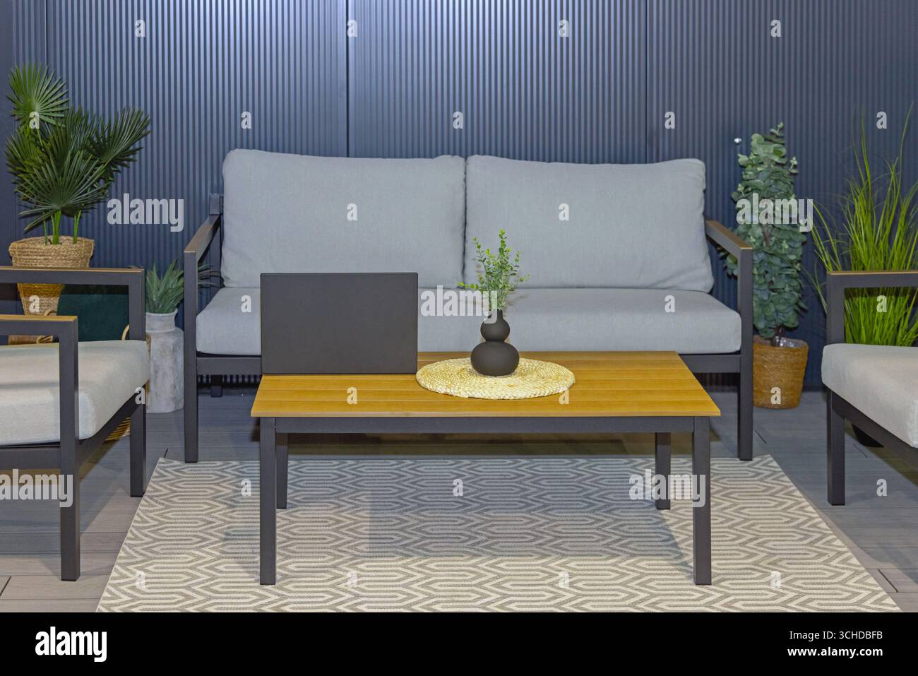 Tavolino da caffè in legno davanti al divano grigio sulla terrazza Foto Stock