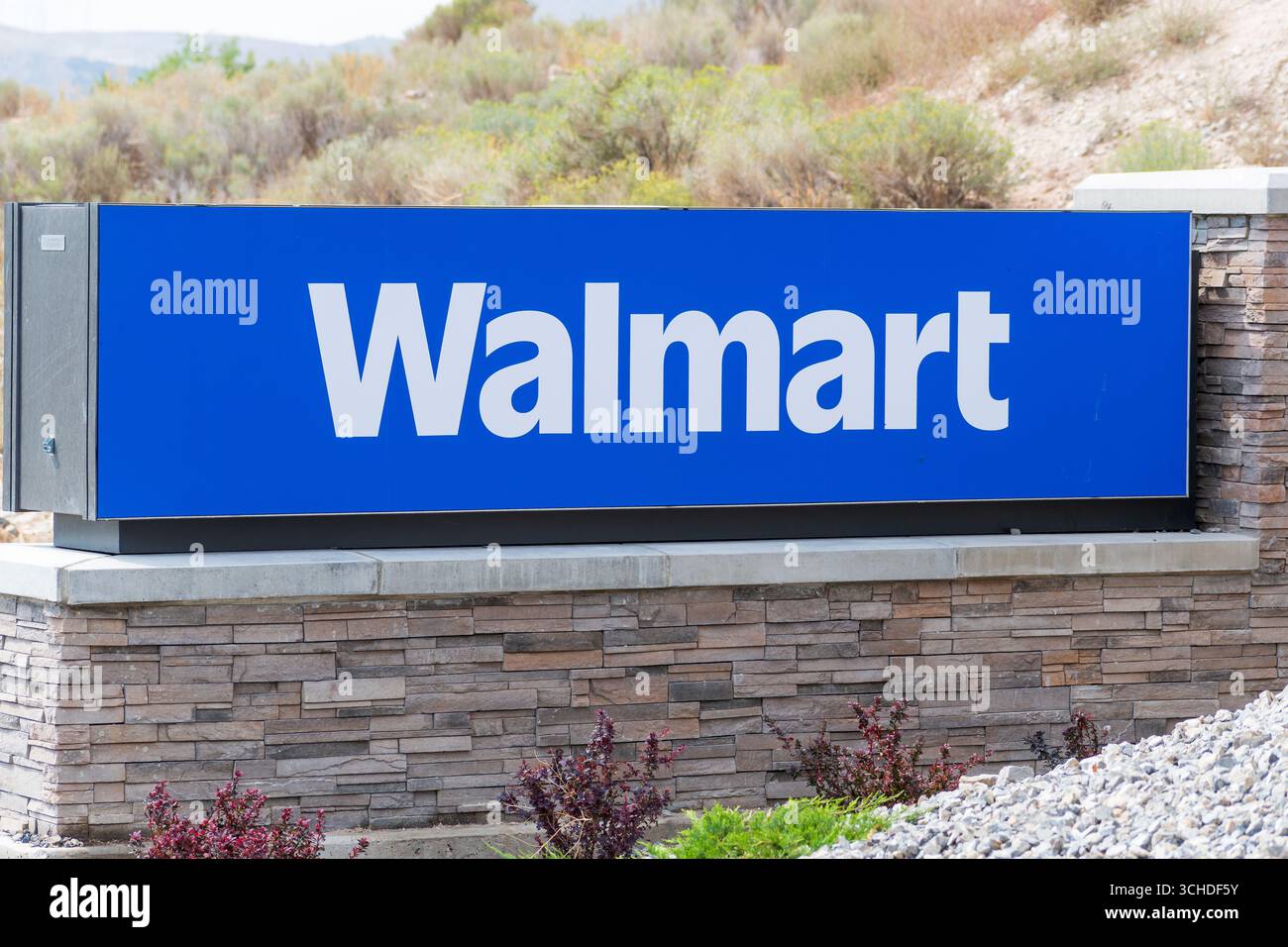 Eagle Mountain, Utah, USA - 1 settembre 2025: Un cartello autoportante di Walmart si trova su una base di pietra circondata da ghiaia e paesaggi desertici. Foto Stock