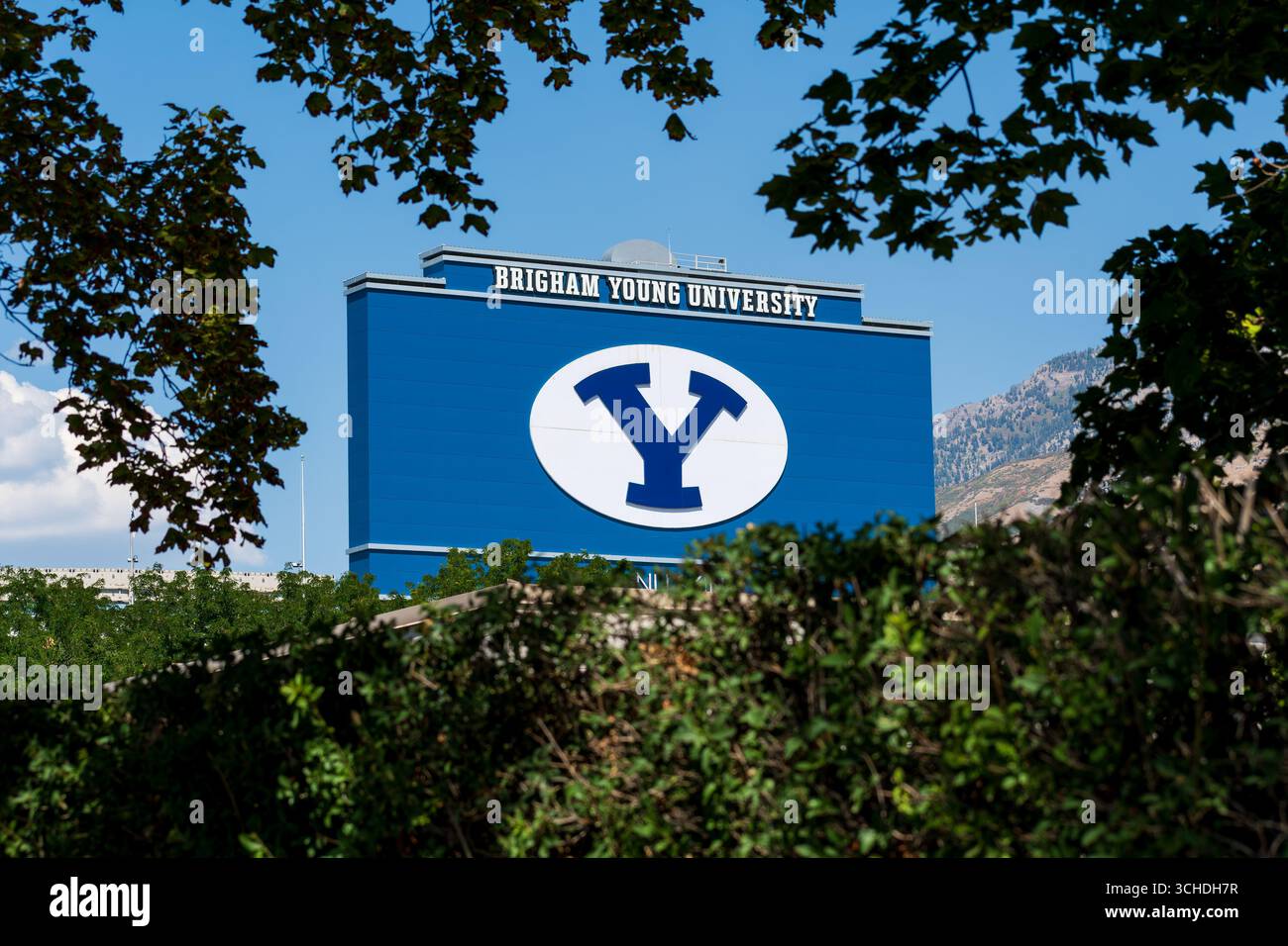 Provo, Utah – 1 settembre 2025: L'iconica insegna a "Y" della Brigham Young University è visibile in un edificio del campus, incorniciata da fogliame e dalla Wasatch Range. Foto Stock