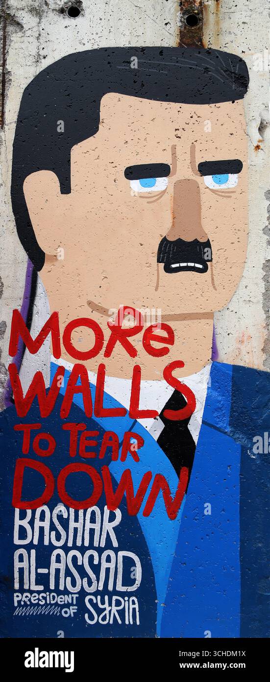 Il suggestivo pezzo di graffiti sul muro di Berlino ritrae Bashar al-Assad, accompagnato da un messaggio potente Foto Stock