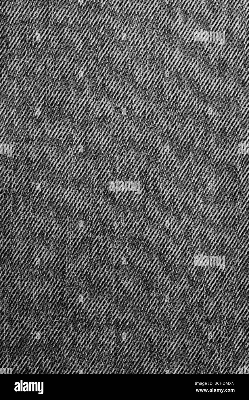 Primo piano di jeans in denim lavati in pietra neri sullo sfondo. Concetto di tessuto di abbigliamento alla moda tradizionale. Foto Stock