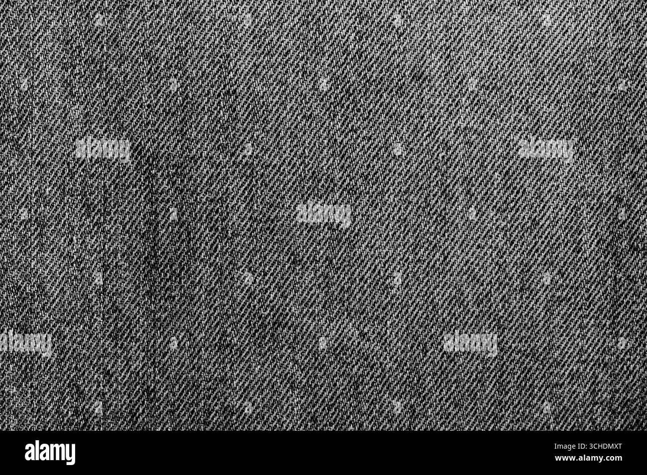 Primo piano di jeans in denim lavati in pietra neri sullo sfondo. Concetto di tessuto di abbigliamento alla moda tradizionale. Foto Stock