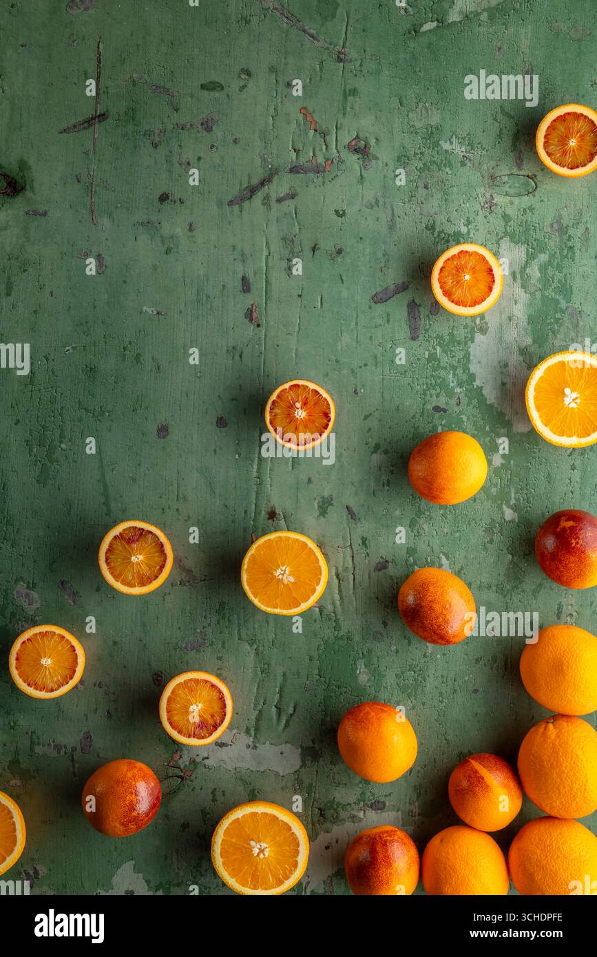 Gli agrumi colorati disposti su una superficie verde creano un'accattivante dimostrazione di freschezza Foto Stock