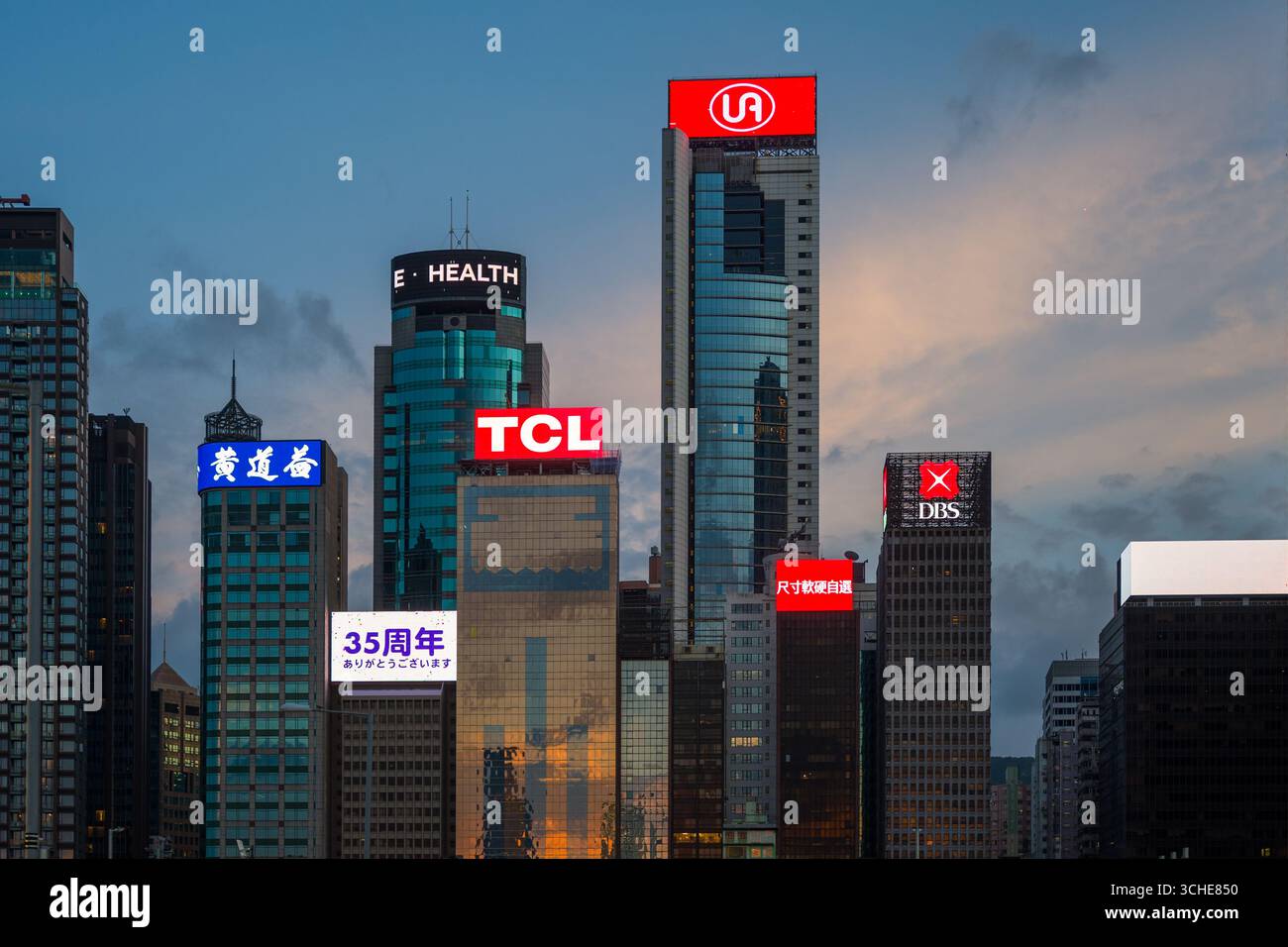 Cartelloni e insegne al neon a LED sulla sommità dei grattacieli di Hong Kong che mostrano pubblicità commerciali di fronte al porto Victoria di Hong Kong Foto Stock