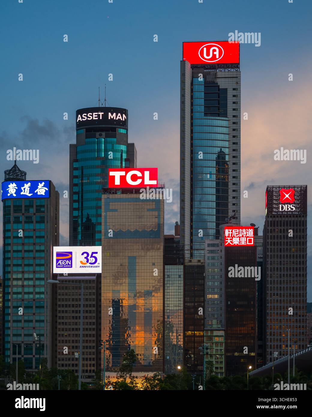 Cartelloni e insegne al neon a LED sulla sommità dei grattacieli di Hong Kong che mostrano pubblicità commerciali di fronte al porto Victoria di Hong Kong Foto Stock