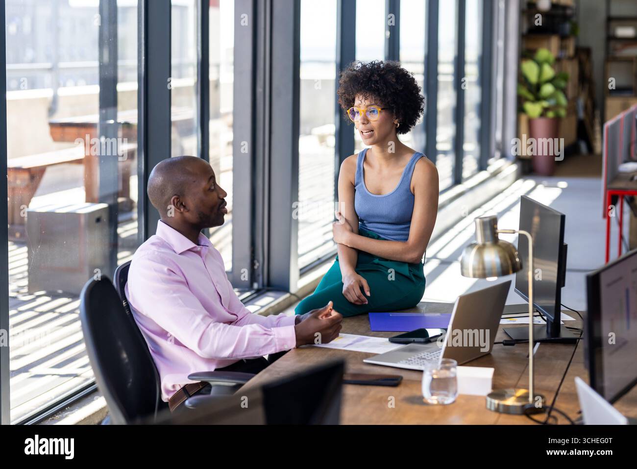 Discussione di progetti in ufficio, colleghi diversi con computer portatili e documenti Foto Stock