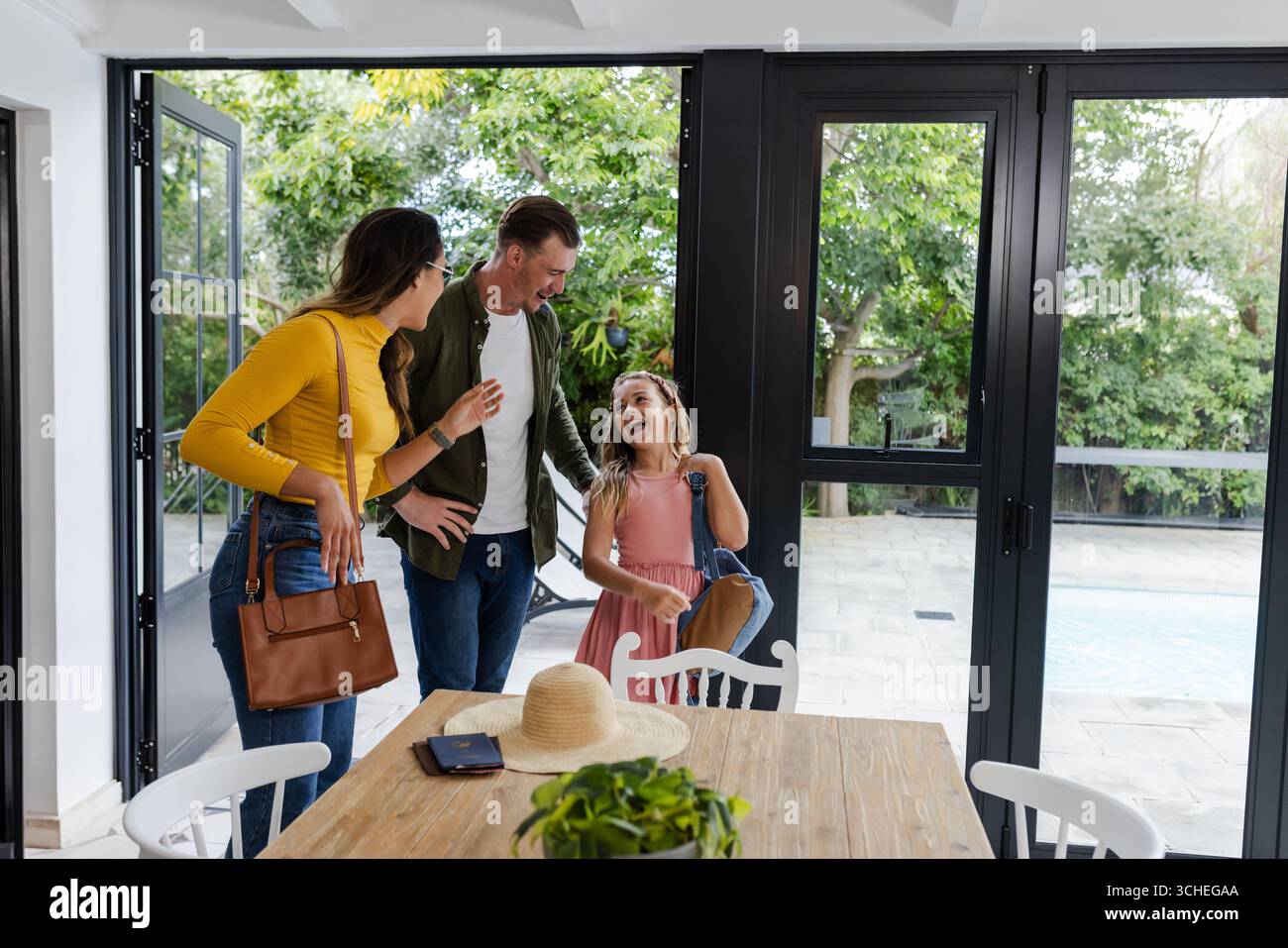 La famiglia può trascorrere momenti di qualità insieme a casa, ridendo vicino al patio a bordo piscina Foto Stock