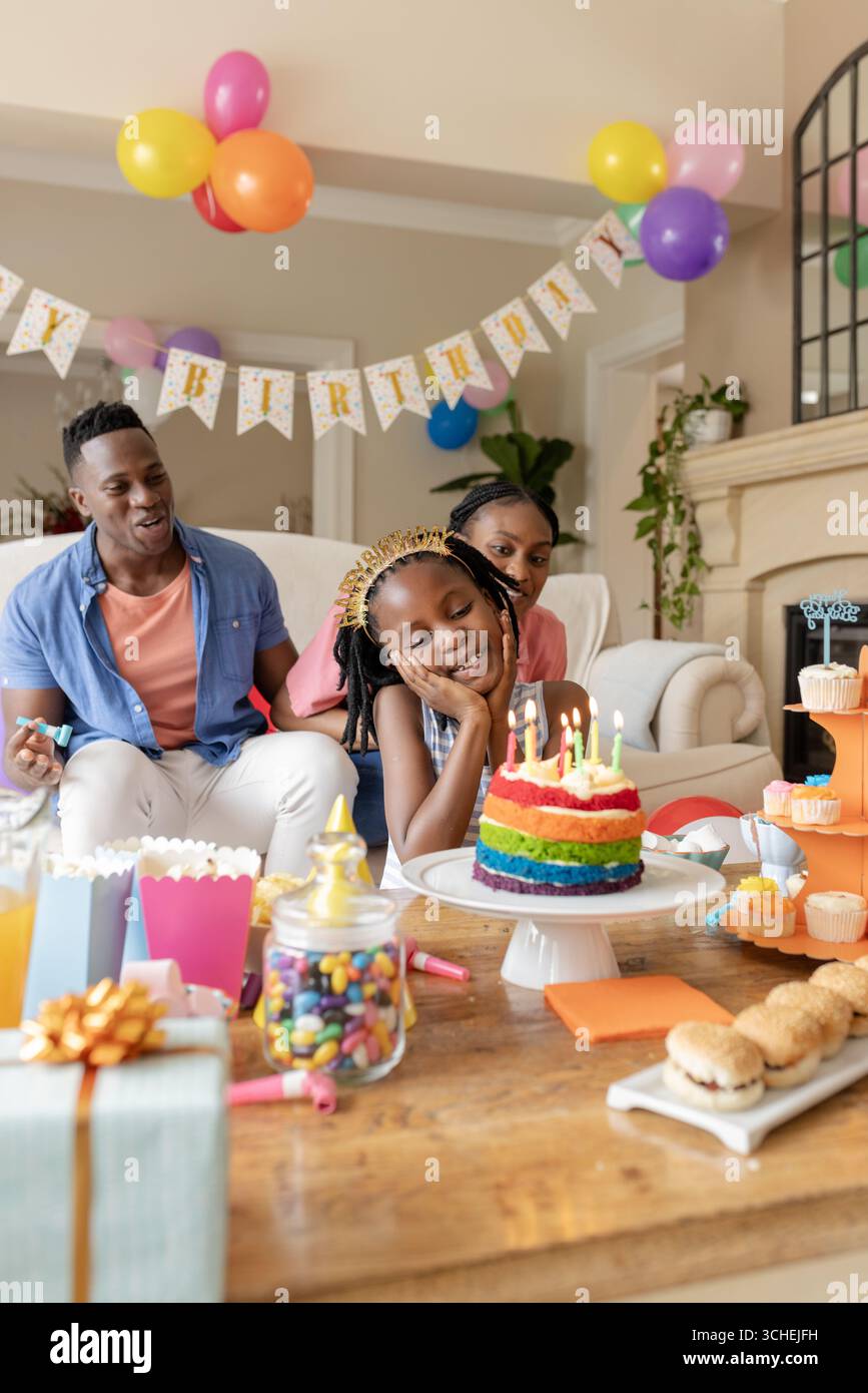 Alla festa, festeggiando il compleanno a casa, la riunione di famiglia intorno alla torta con decorazioni colorate Foto Stock