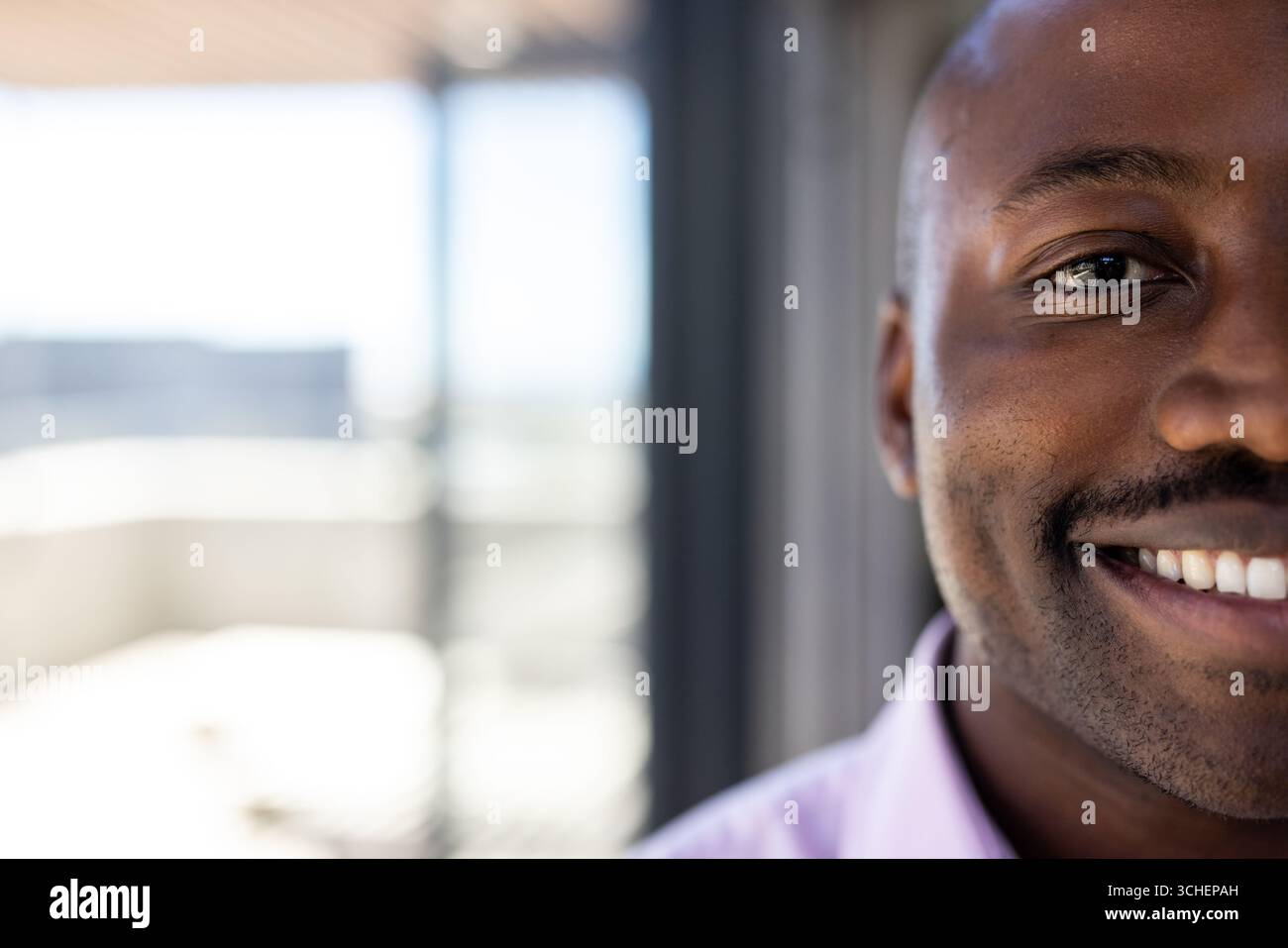 Uomo sorridente in un abbigliamento semi-formale in ufficio, sentendosi sicuro, copiando spazio Foto Stock