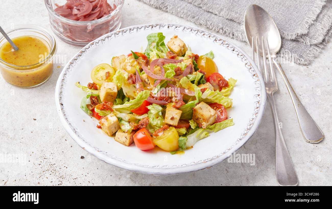 Insalata di tofu con salsa di senape e pomodori ciliegini Foto Stock