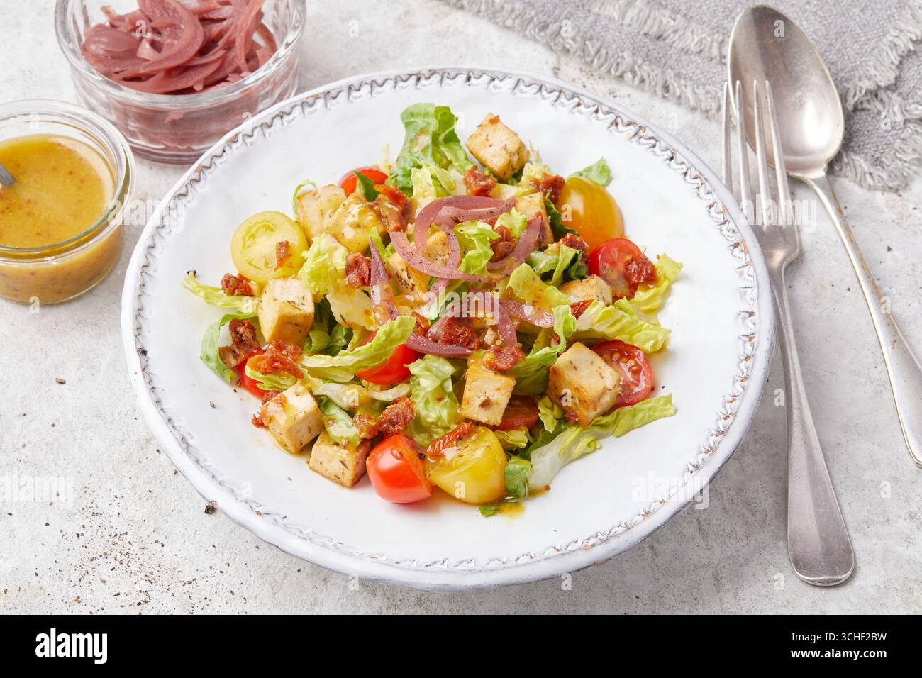Insalata di tofu con salsa di senape e pomodori ciliegini Foto Stock