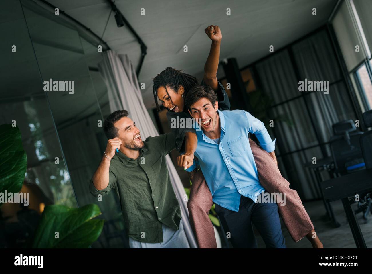 Un gruppo di giovani lavoratori d'ufficio multirazziali e diversificati viene colto in un momento di gioia spontanea. Foto Stock