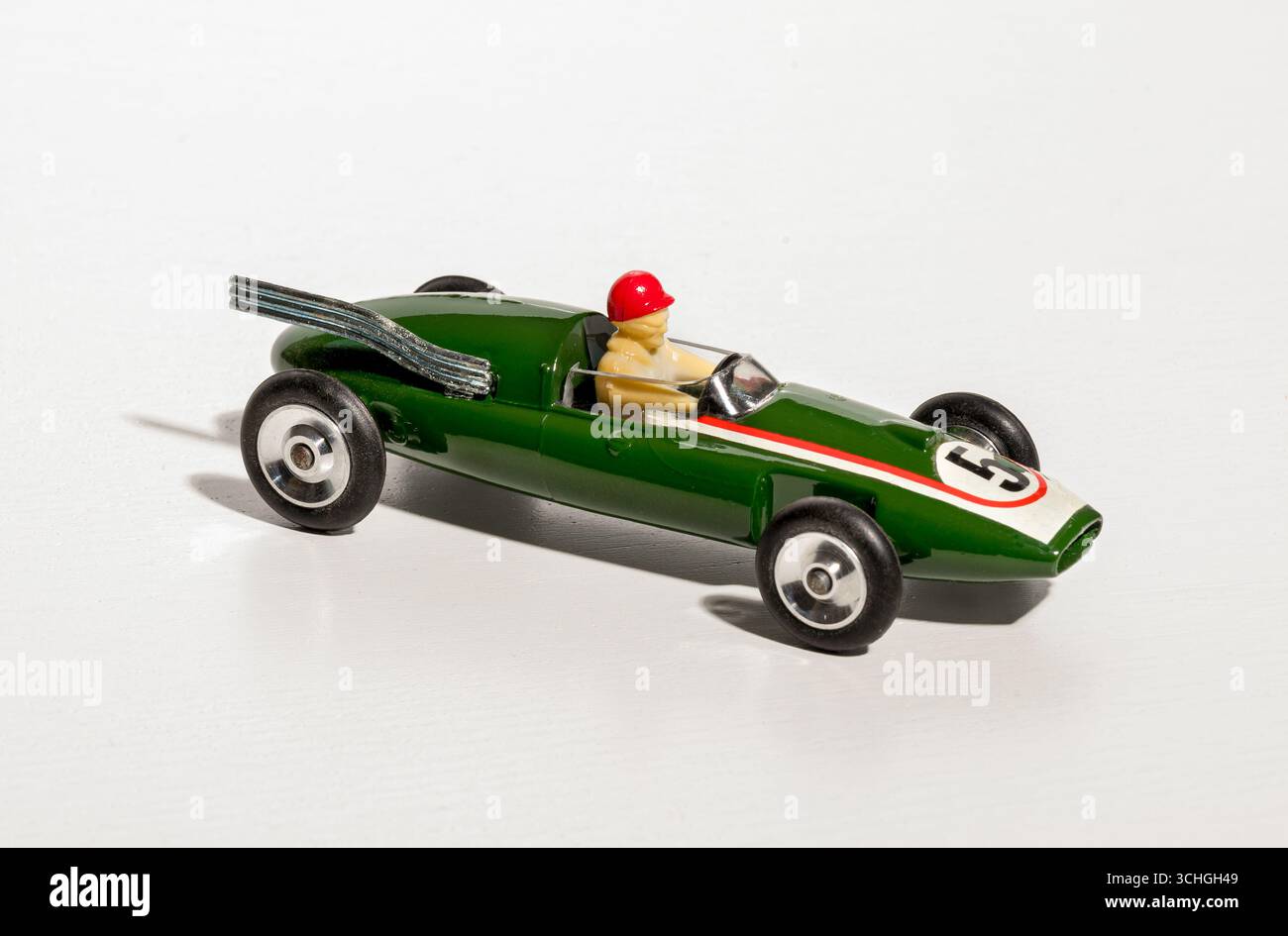 Auto da corsa giocattolo verde d'epoca con pilota su sfondo bianco Foto Stock