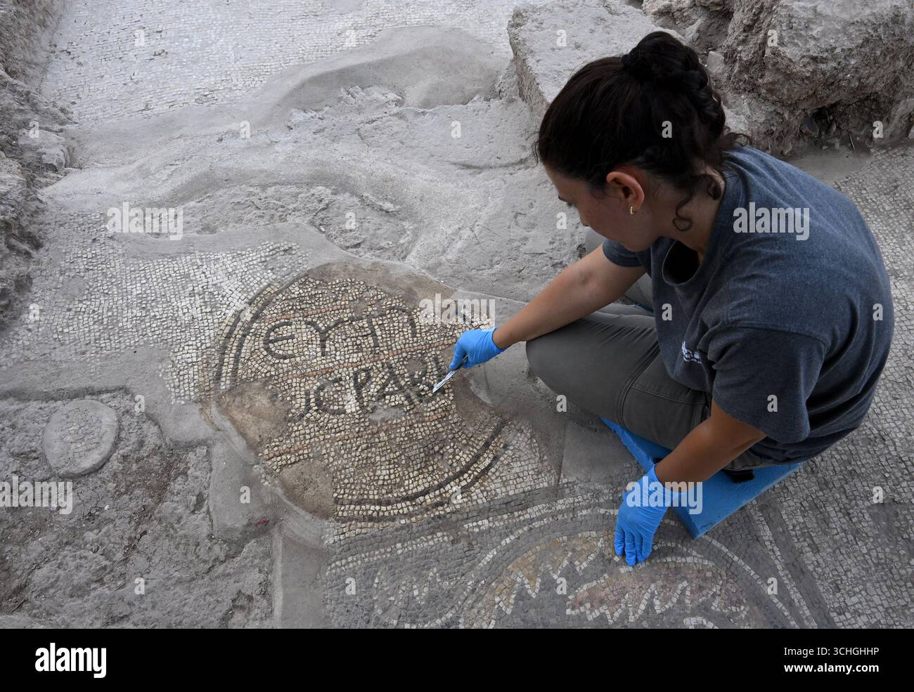 Kafar Qasim, Israele. 2 settembre 2025. Un operaio dell'Autorità delle Antichità di Israele lavora su un mosaico in greco che dice buona fortuna, rinvenuto in una vasta tenuta agricola samaritana, 1.600 anni, IV-VII secolo d.C. - periodo bizantino, martedì 2 settembre 2025, nella città araba di Kafar Qasim, nel centro di Israele. Questo ricco insediamento, che si crede sia il luogo di nascita di Menandro, il mago samaritano, successore di Simon Magus, che era considerato il padre delle sette gnostiche e uno dei primi convertiti del cristianesimo. Crediti: UPI/Alamy Live News Foto Stock