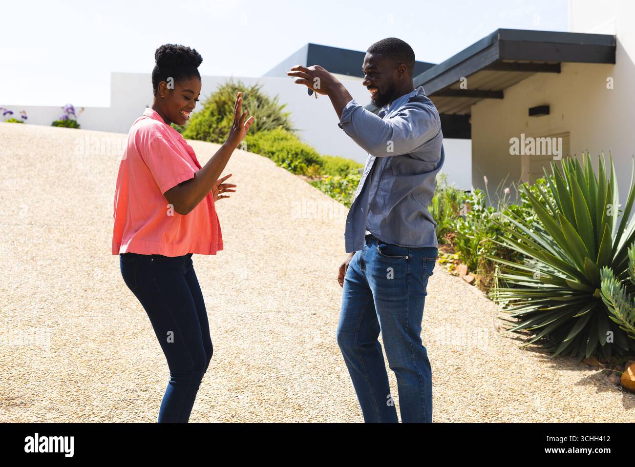 Coppie che ballano gioiosamente all'aperto, godendosi la giornata di sole e la compagnia reciproca Foto Stock
