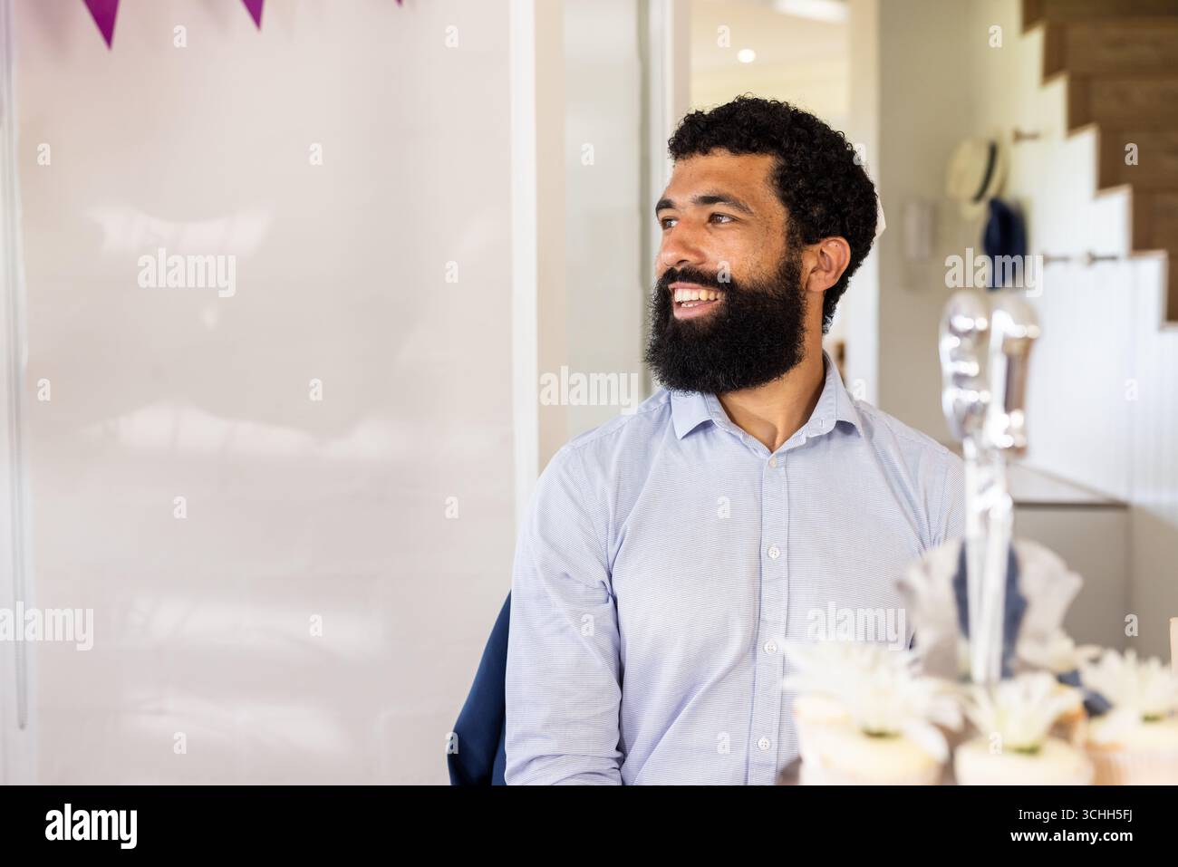 Padre sorridente che si diverte a festeggiare in casa con cupcake sul tavolo, a casa, spazio per le copie Foto Stock