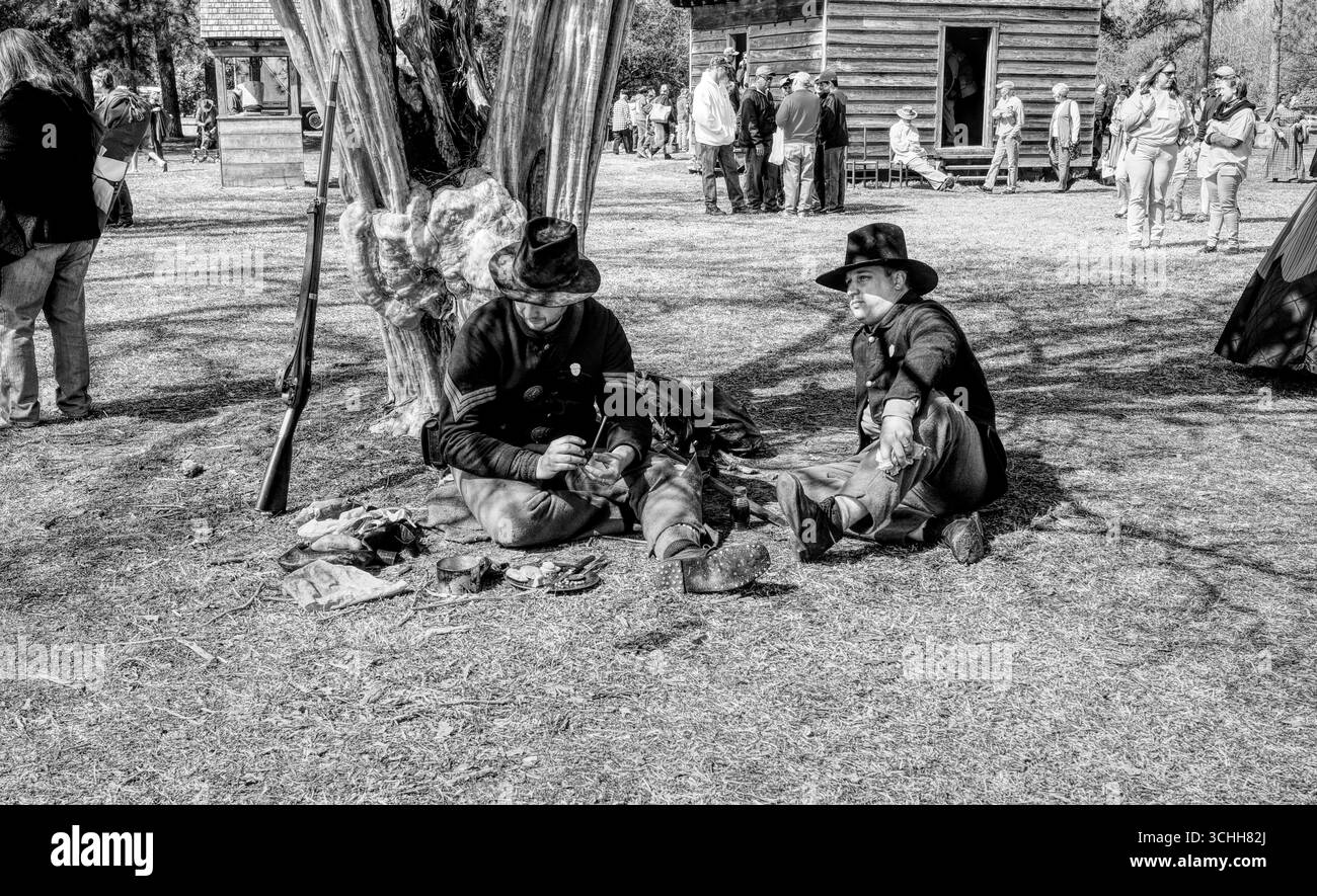 Due reenattori della guerra civile seduti vicino a un albero strano Foto Stock