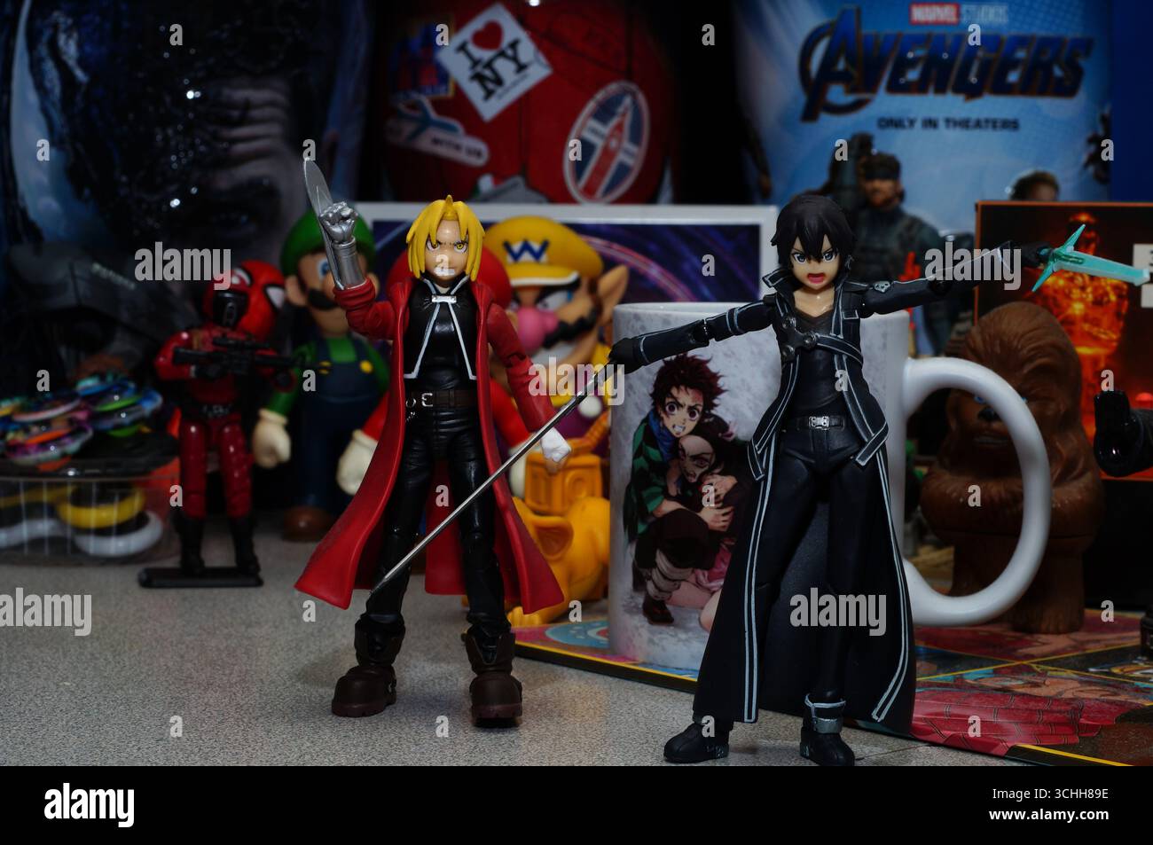 Due figurine di Anime Figma esposte su una scrivania piena di altri oggetti e giocattoli della cultura pop Foto Stock