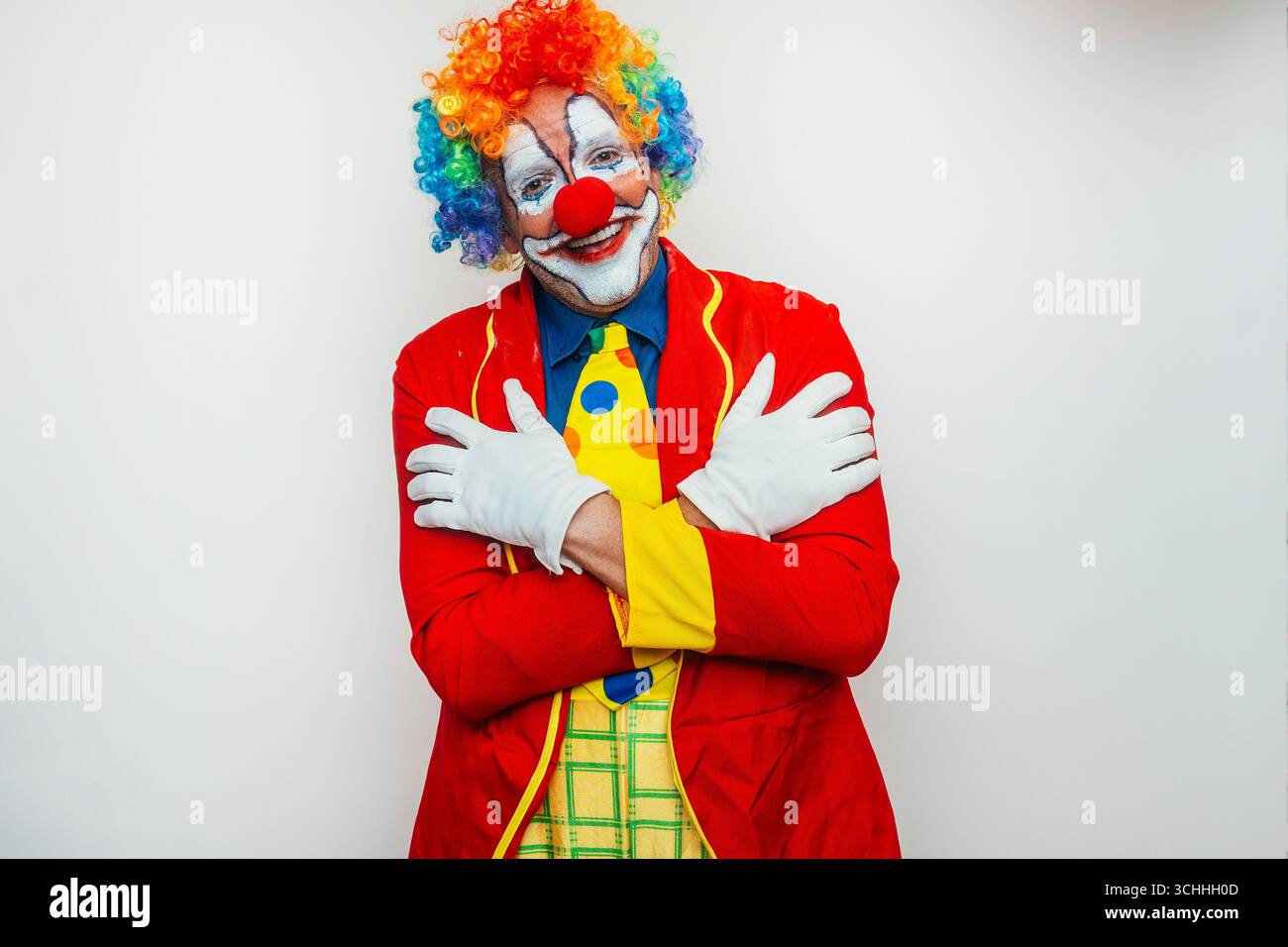 Clown con le braccia incrociate e un volto amichevole Foto Stock