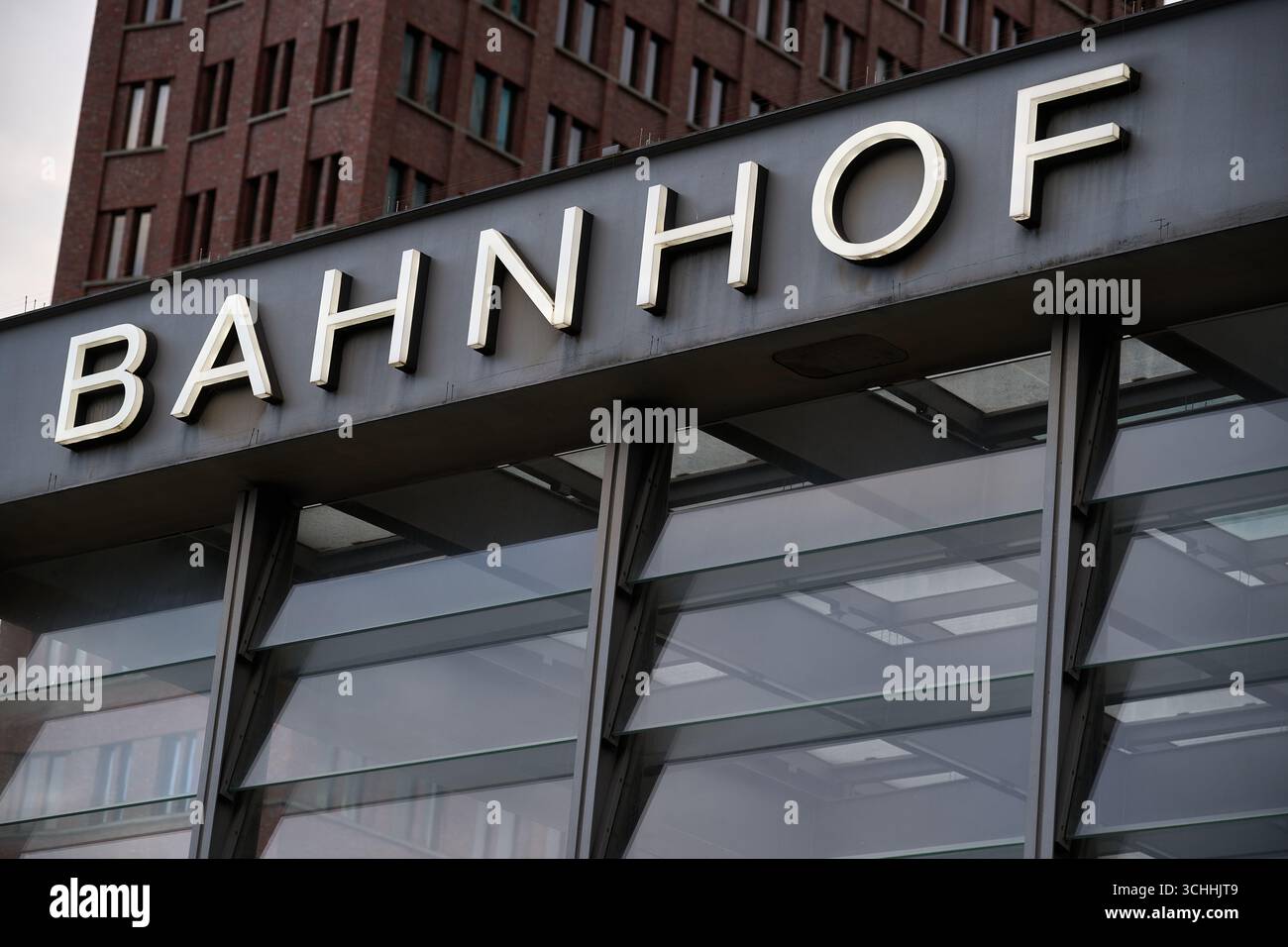Primo piano del cartello della stazione ferroviaria "Bahnhof", Berlino, lettere in grassetto alla luce del giorno, orientamento orizzontale, struttura metallica, contesto urbano, uso editoriale per Foto Stock