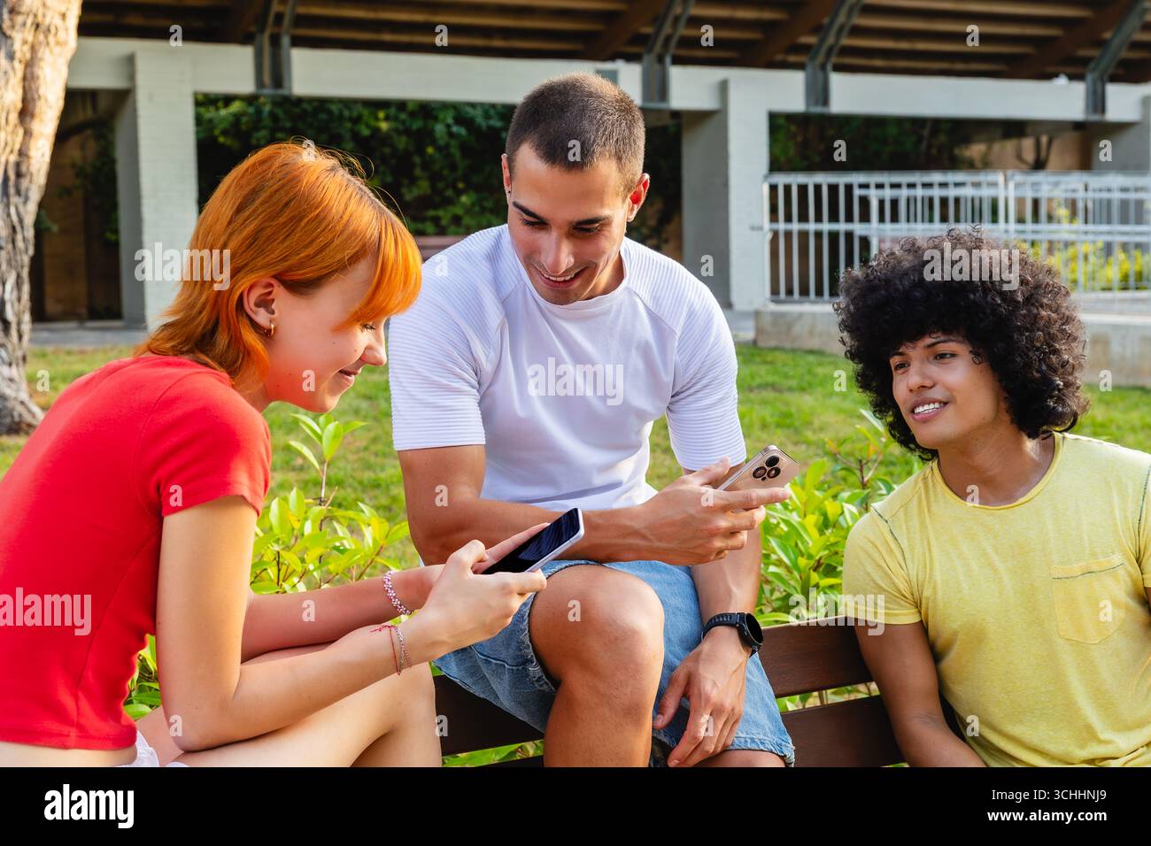 Gruppo di giovani che usano smartphone sul banco Foto Stock