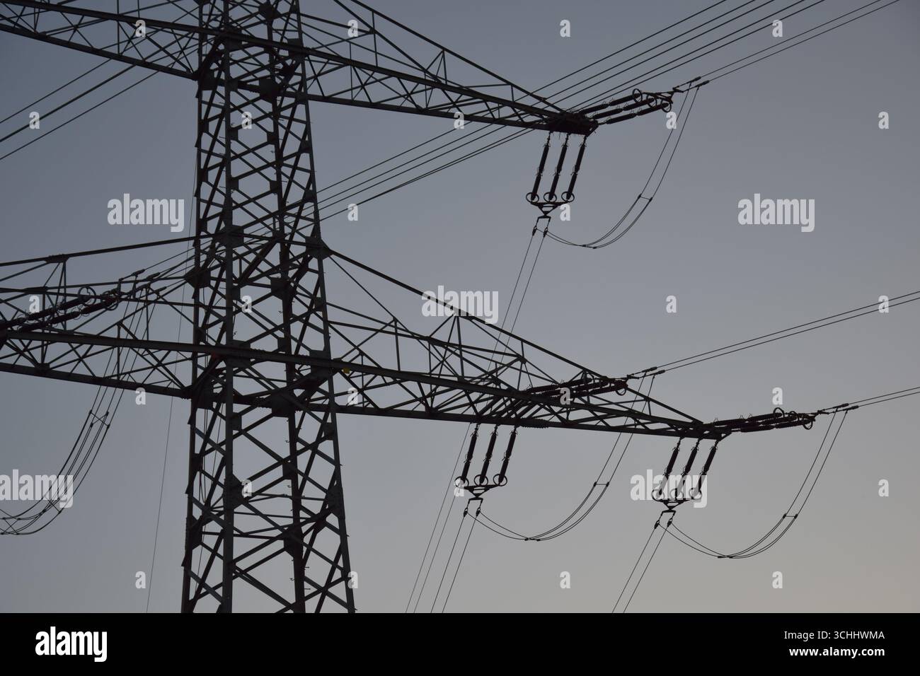 Primo piano della struttura a piloni elettrici con cavi all'ora blu dopo il tramonto, formato del paesaggio, simbolo dell'energia e delle infrastrutture in Germania. Foto Stock