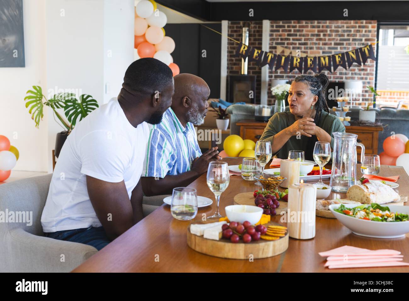 Festeggiamo la pensione, gli amici condividono cibo e bevande, raccontano storie a casa Foto Stock