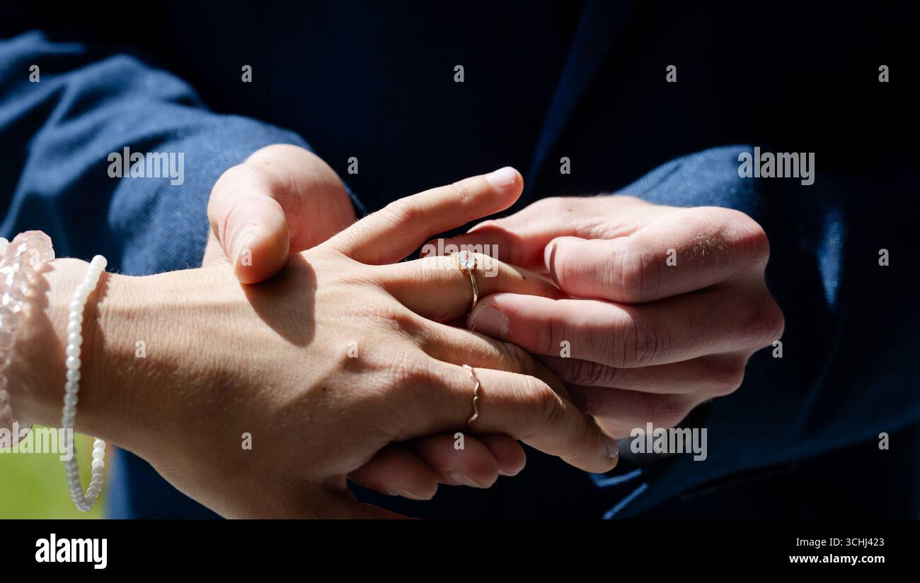 Scambiarsi anelli, coppie che celebrano la cerimonia nuziale con amore e impegno Foto Stock