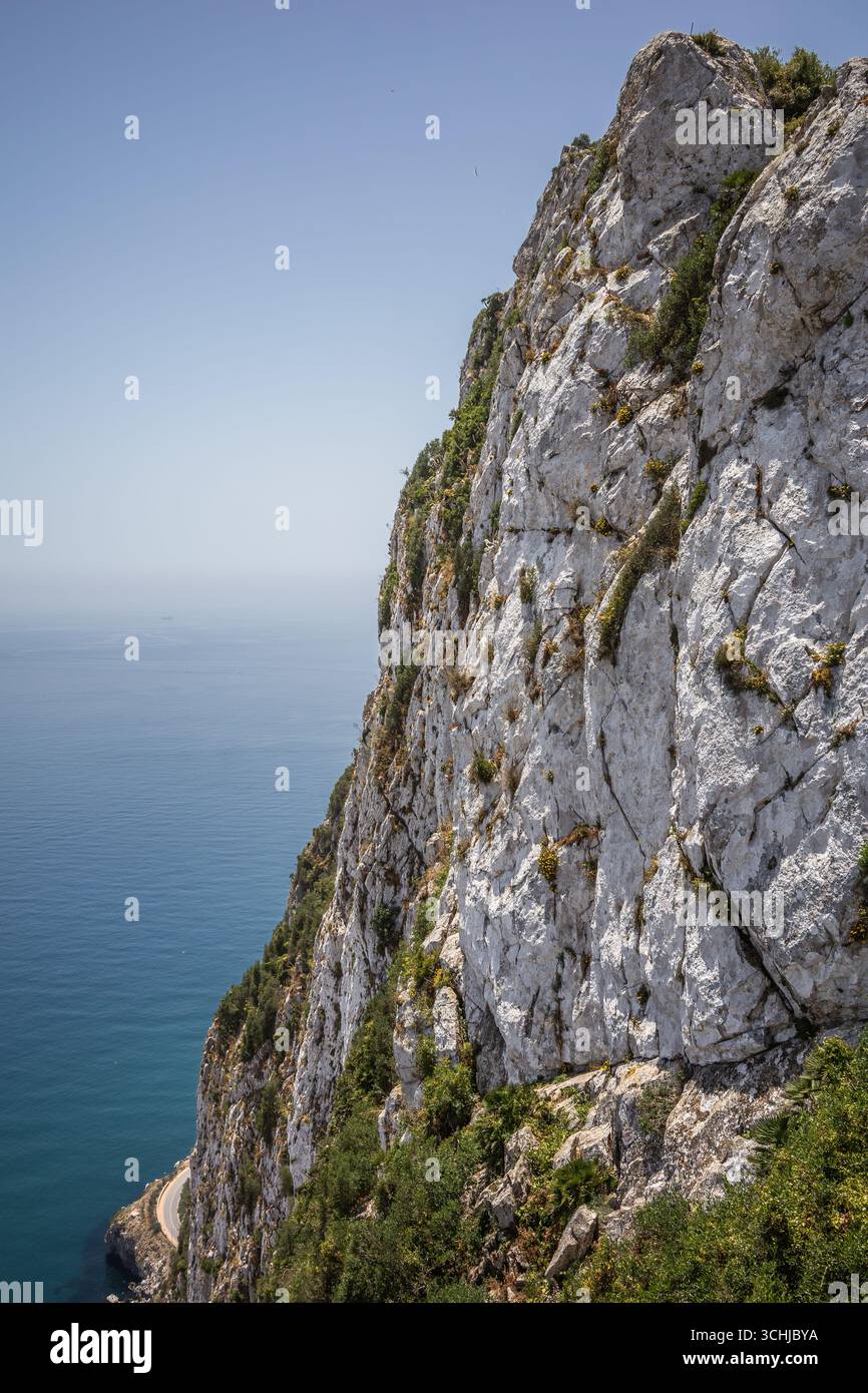Paesaggio verticale della montagna calcarea rocciosa con il Mar Blu. Splendida High Rock a Gibilterra. Scogliera di pietra con acqua nella penisola iberica. Foto Stock