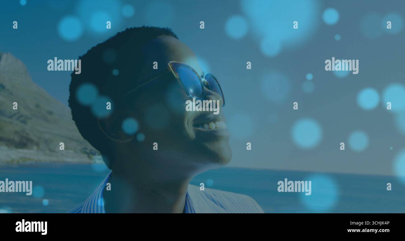 Donna sorridente in piedi sul litorale con occhiali da sole Cat-eye e camicia a righe, spazio copia Foto Stock