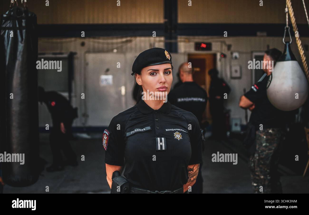 Ritratto di una donna della Gendarmeria in uniforme, in piedi all'interno di una base militare. Foto Stock