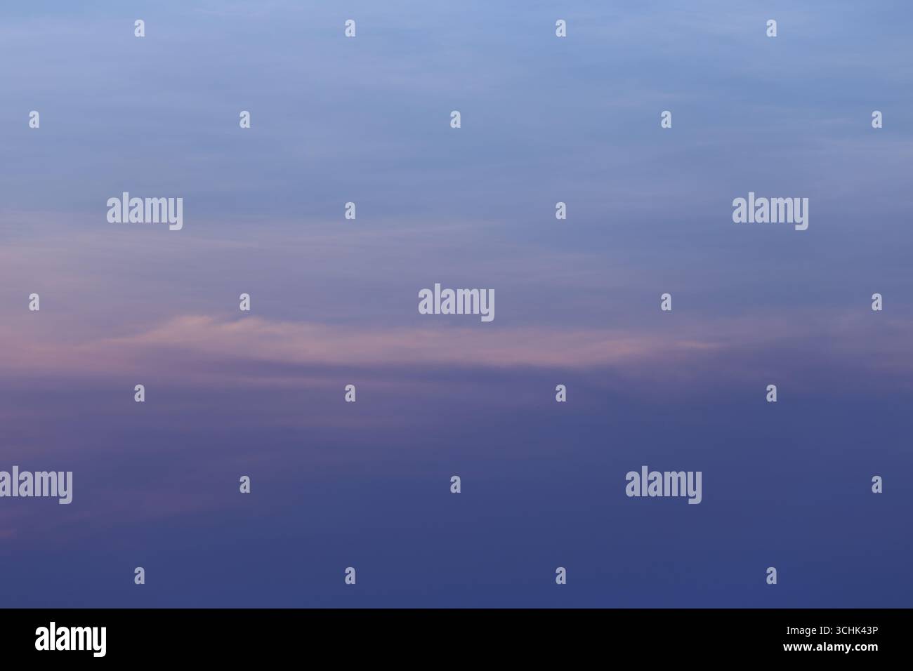 Questa immagine cattura un tranquillo cielo al tramonto con sfumature di rosa, viola e blu, ideale per aggiungere elementi rilassanti a qualsiasi design o progetto artistico Foto Stock